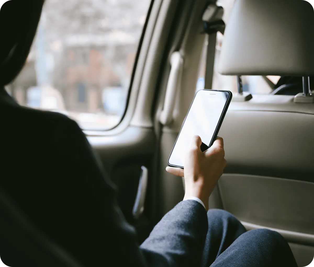 A person checking their email in the back of a taxi