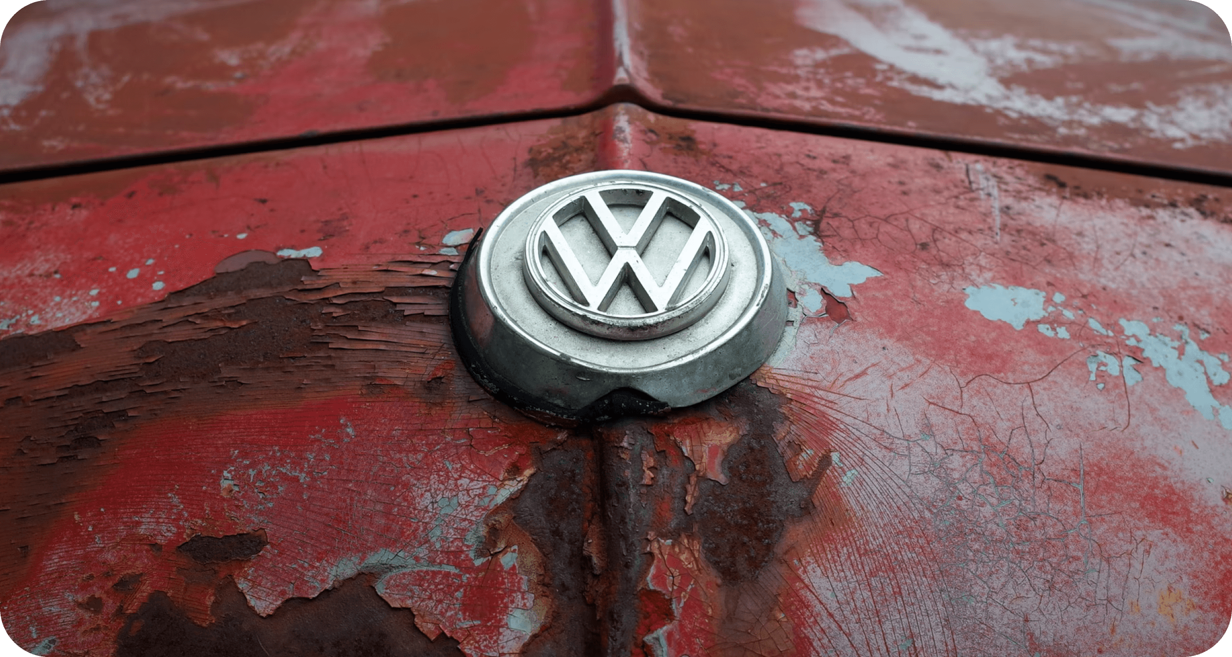 Volkswagen badge, shown on an old red car