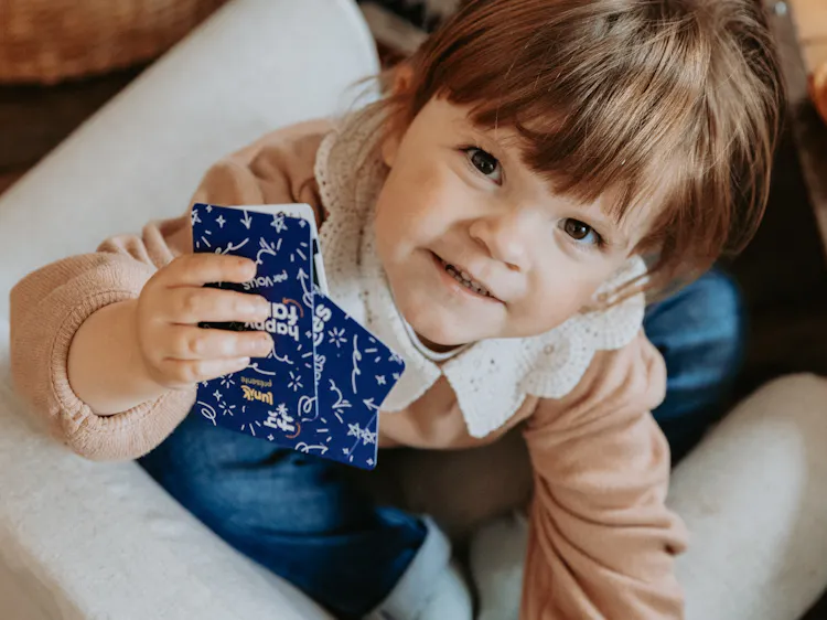 Child playing a personalized game of Happy Families