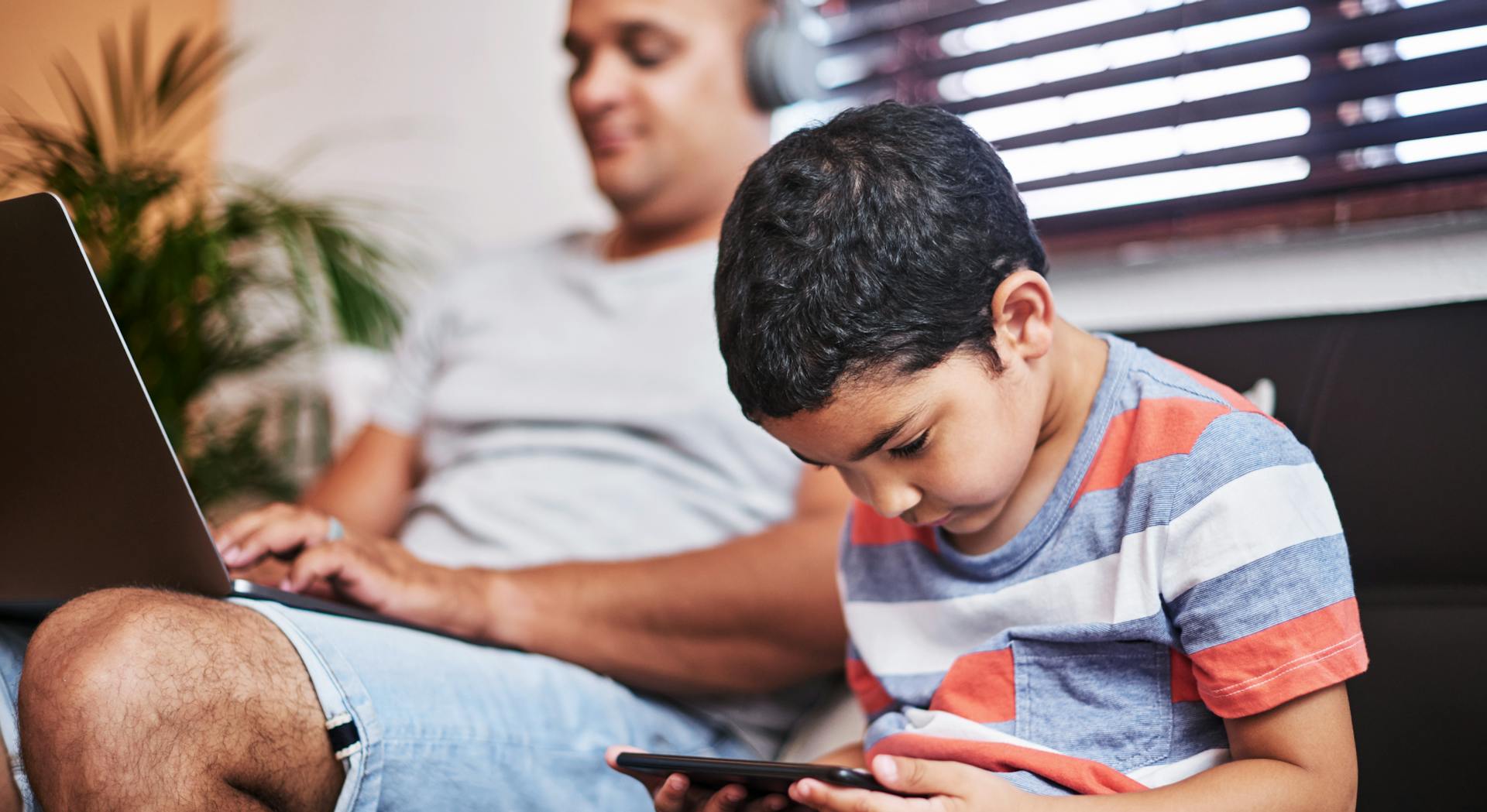 Father and son using devices
