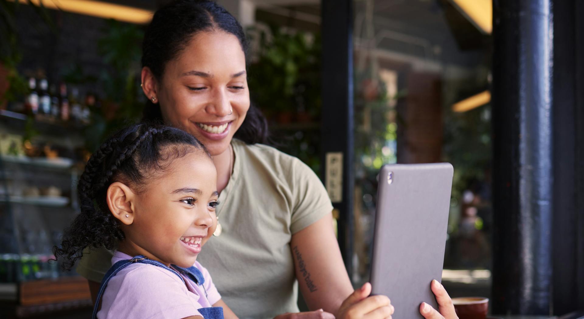 Mother and daughter using a tablet together, smiling