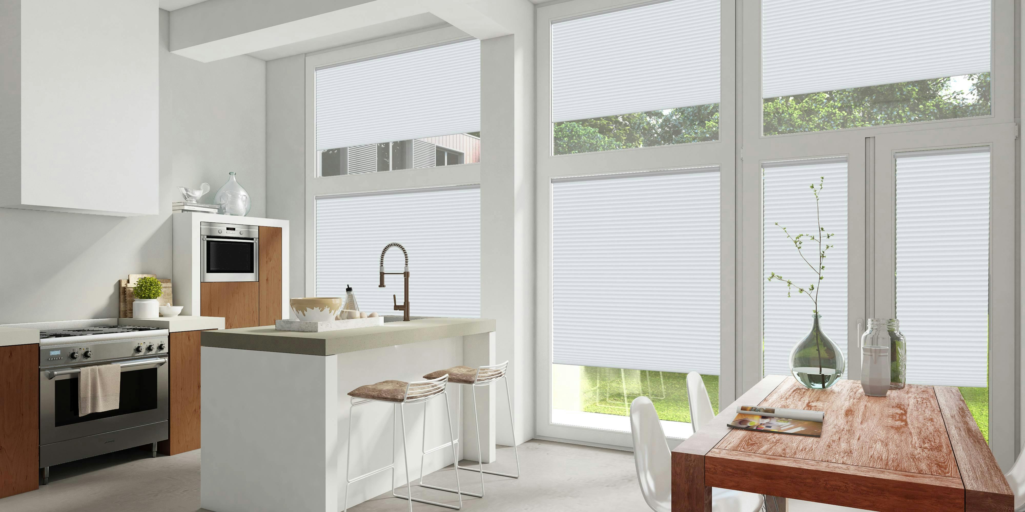 White kitchen with white Plissé blinds on large windows and patio door
