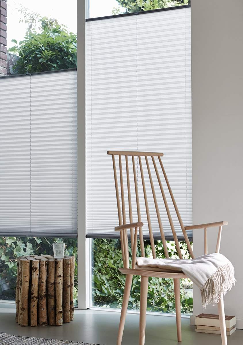 White Plissé blinds on windows in a light room 
