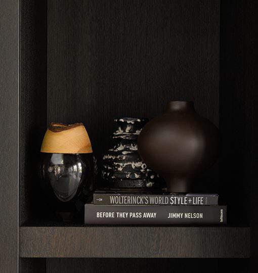 Living room dark bookshelf with vase and books