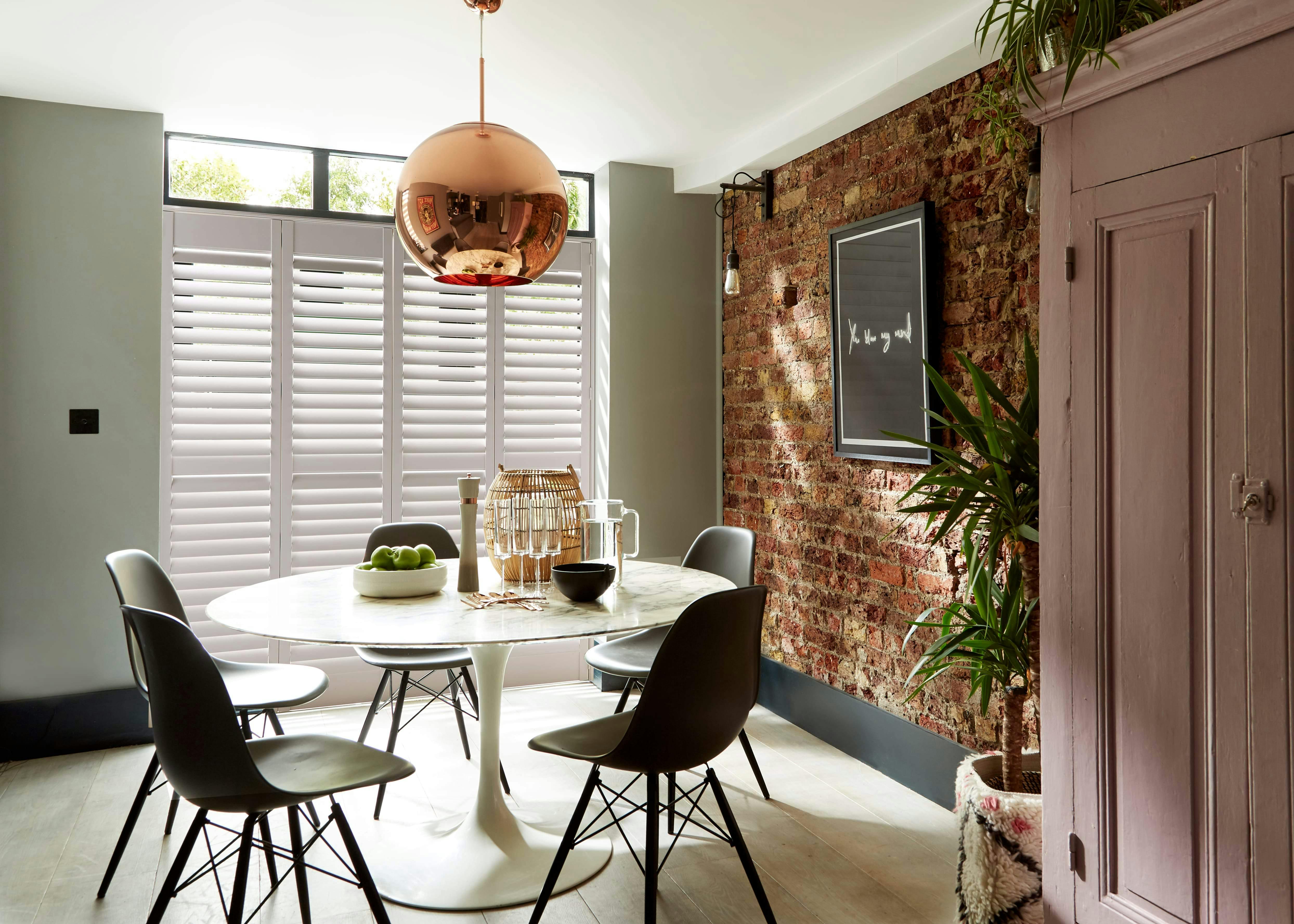 Sunny dining room with white Shutters on windows 