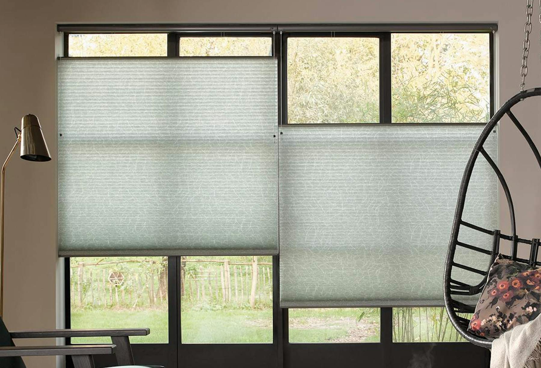 Modern living room with light green Duette® Blinds on windows