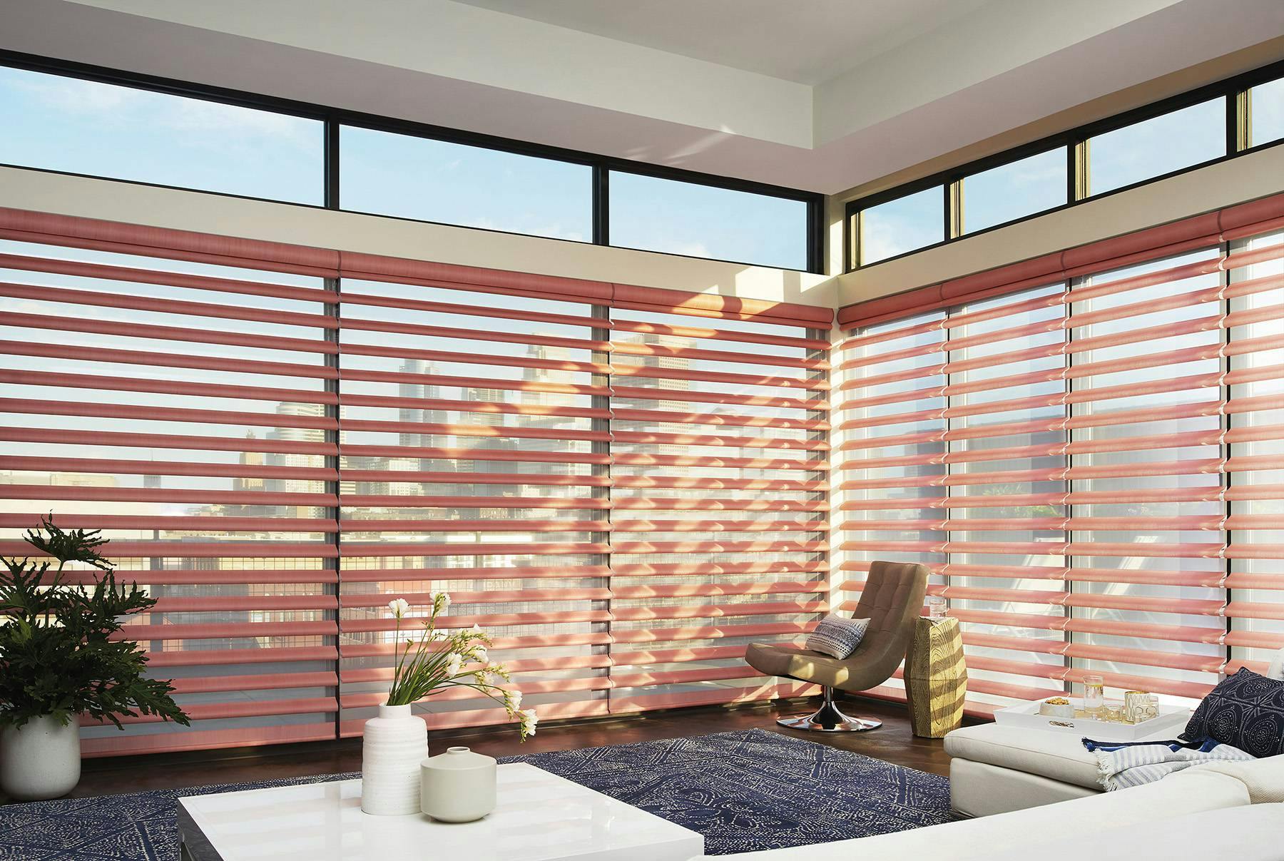 Sunny living room with pink Pirouette® Shades on large windows