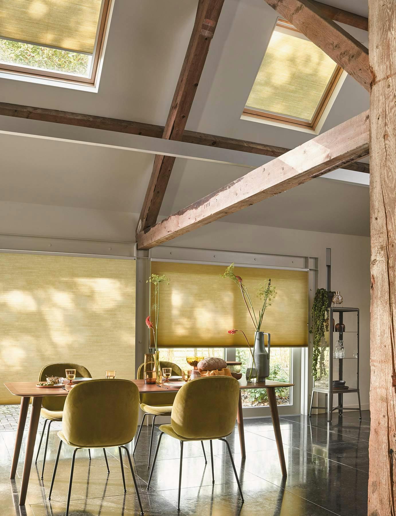 Sunny dining room with yellow Duette® Blinds on windows