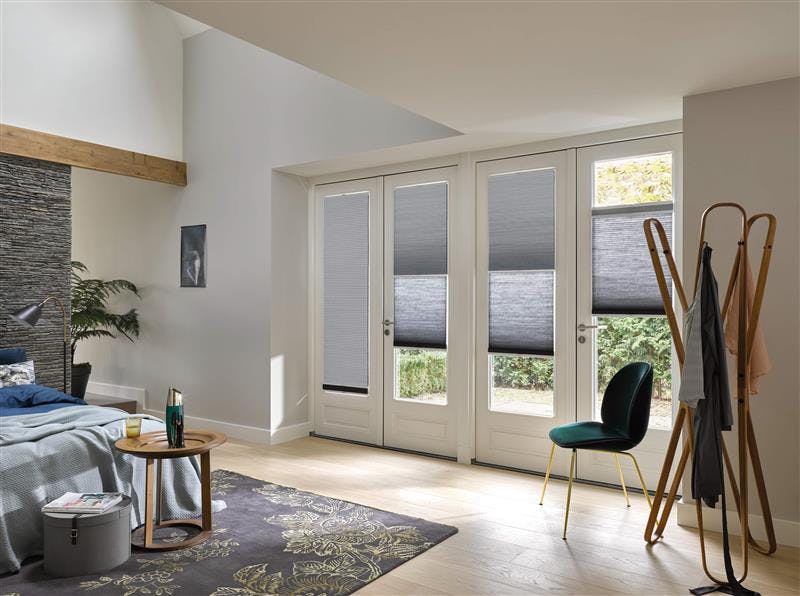 Modern bedroom with grey duette blinds on patio door