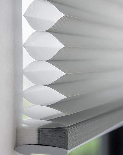 Close up side view of white duette blinds