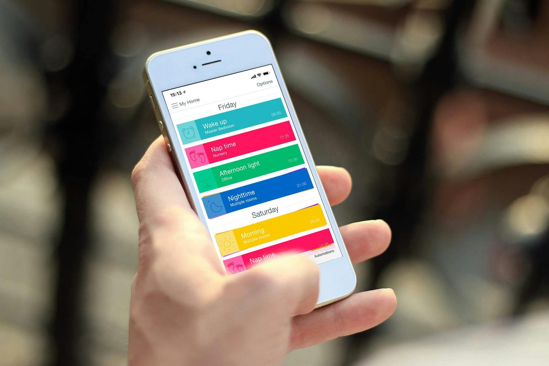 Hand holding a mobile device with PowerView® automation on the display