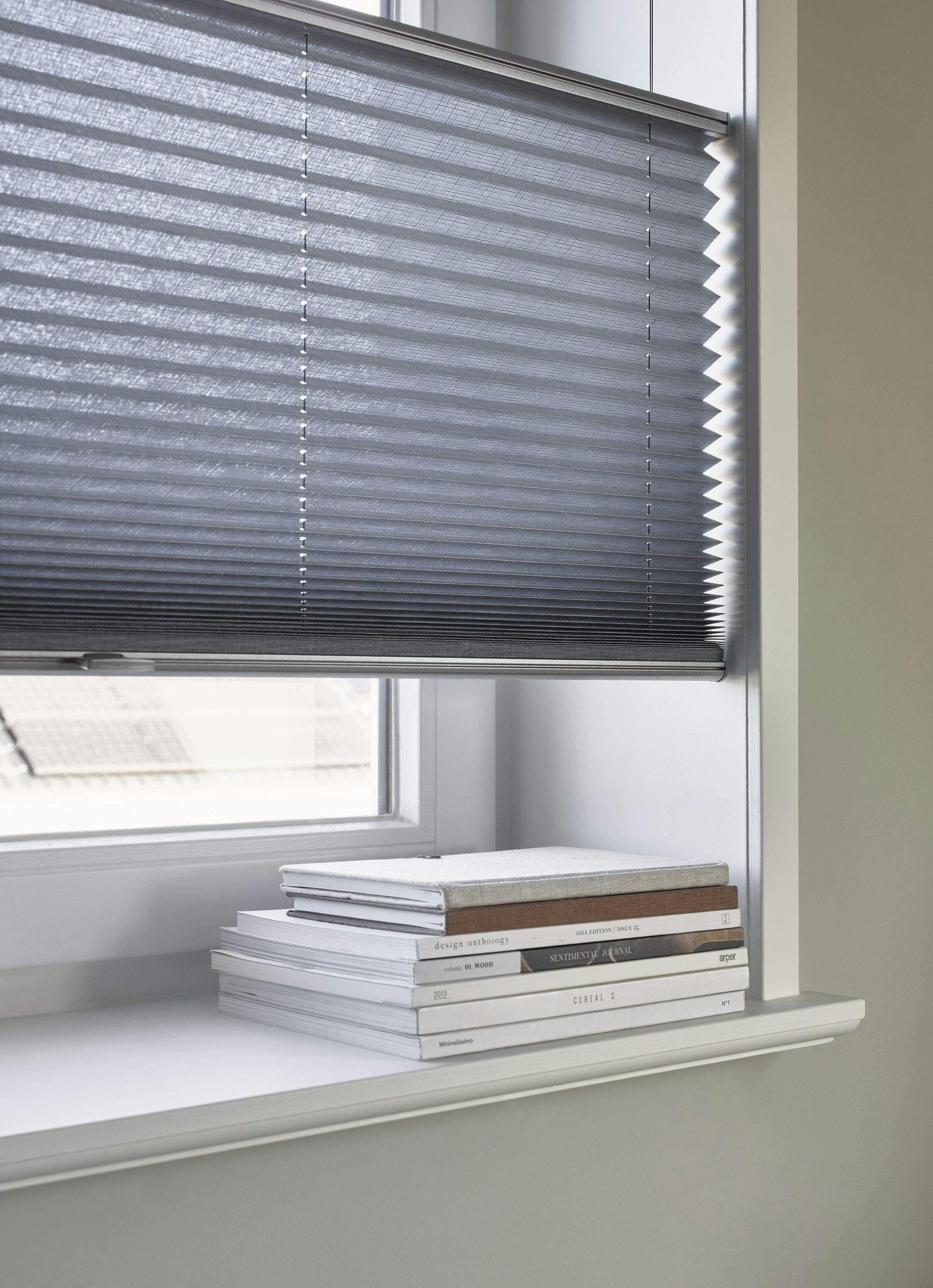 Side view of grey Plissé shades on a standard window