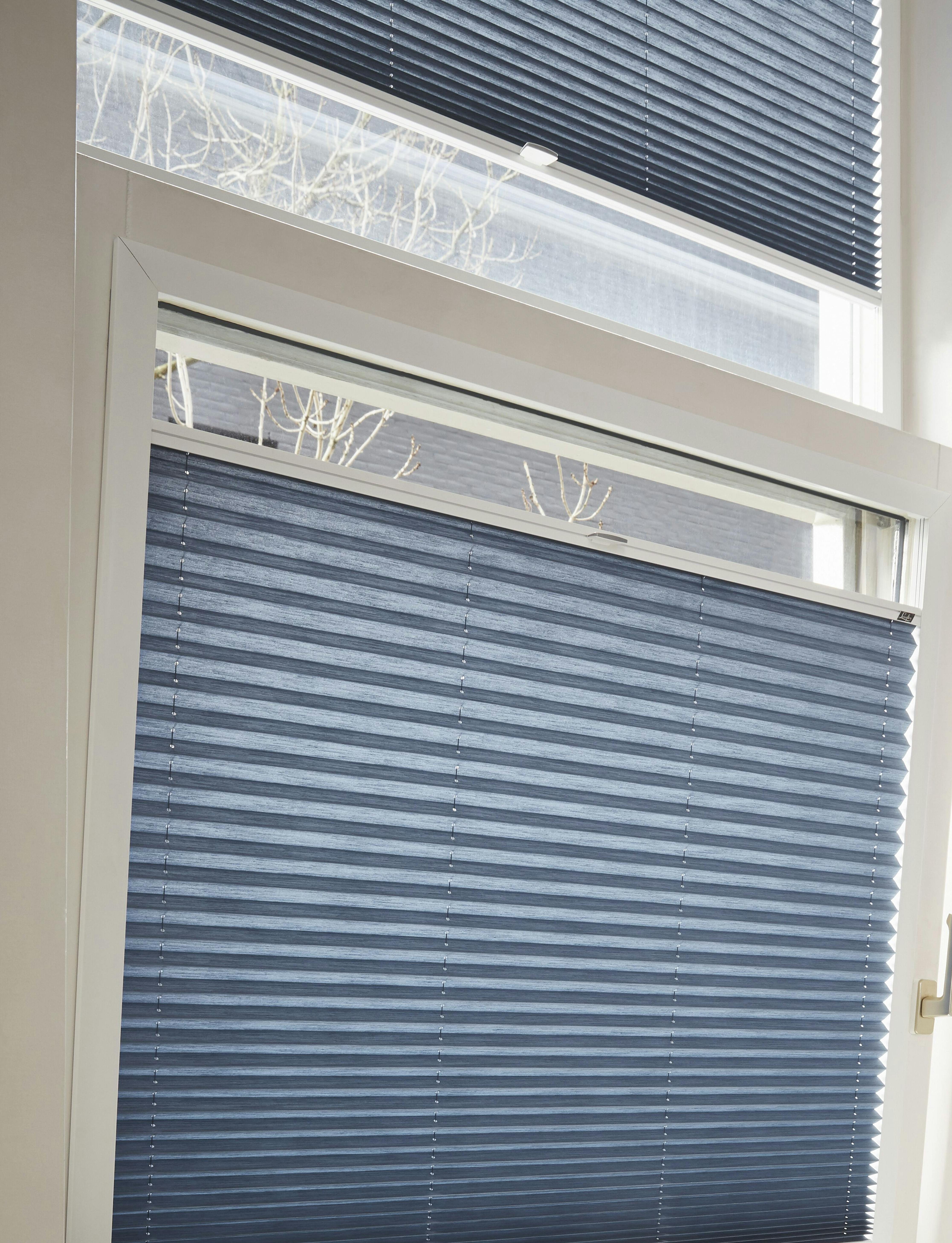 Vippfönster med blå plisségardiner