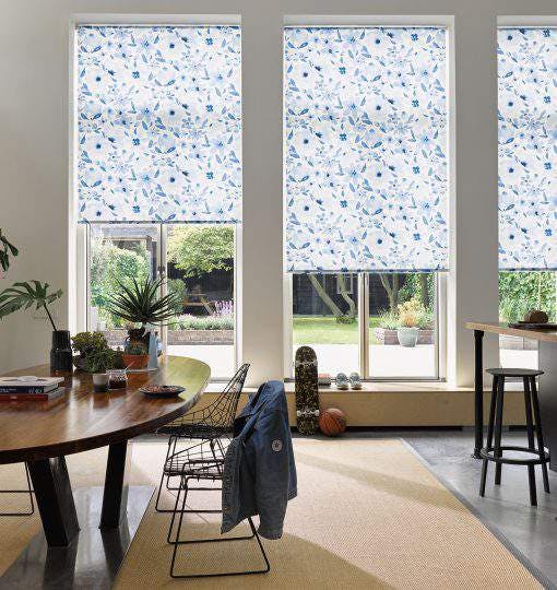 Light dining room with blue patterned roller blinds on windows