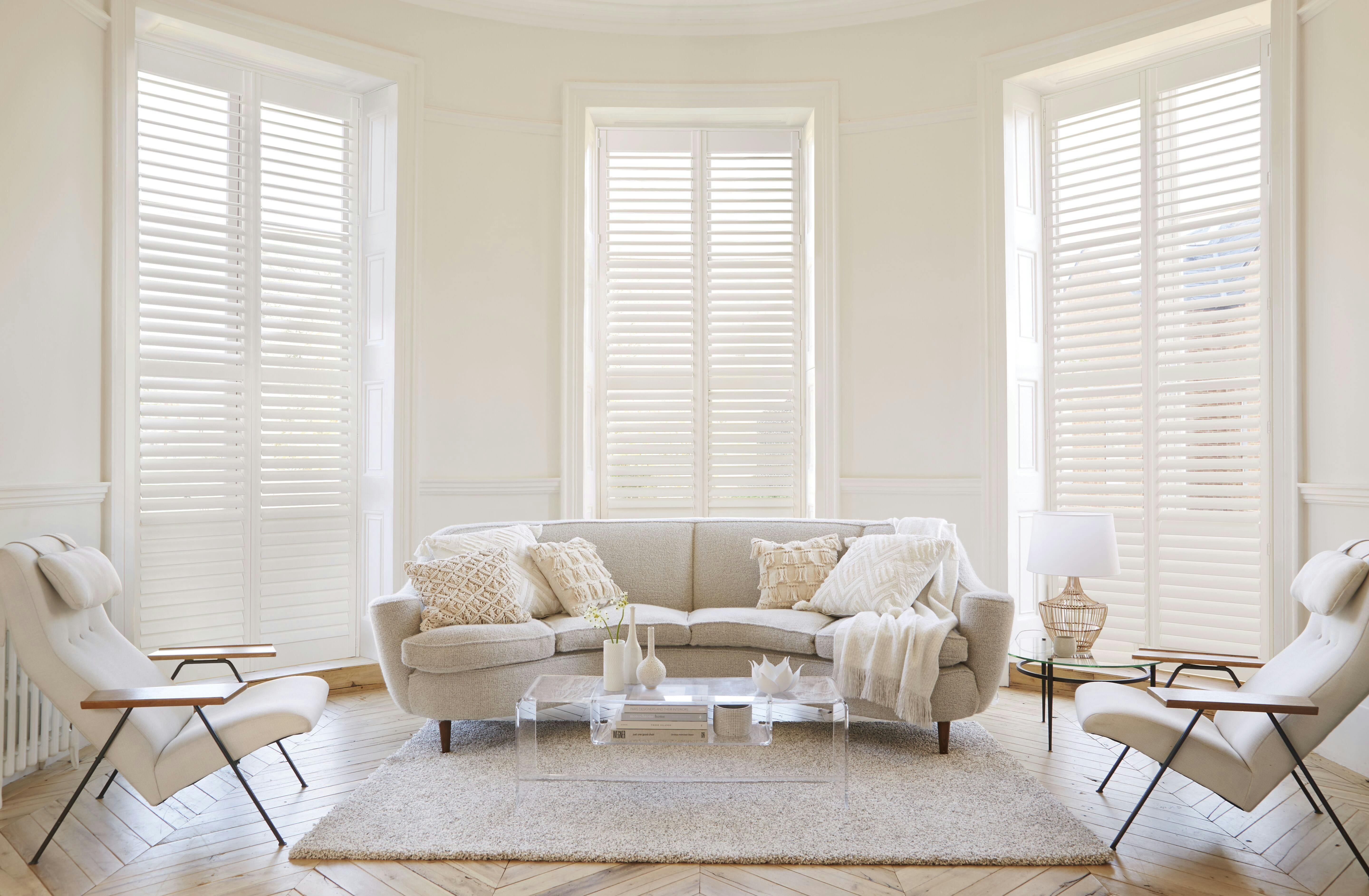 White living room with white Shutters on bay windows