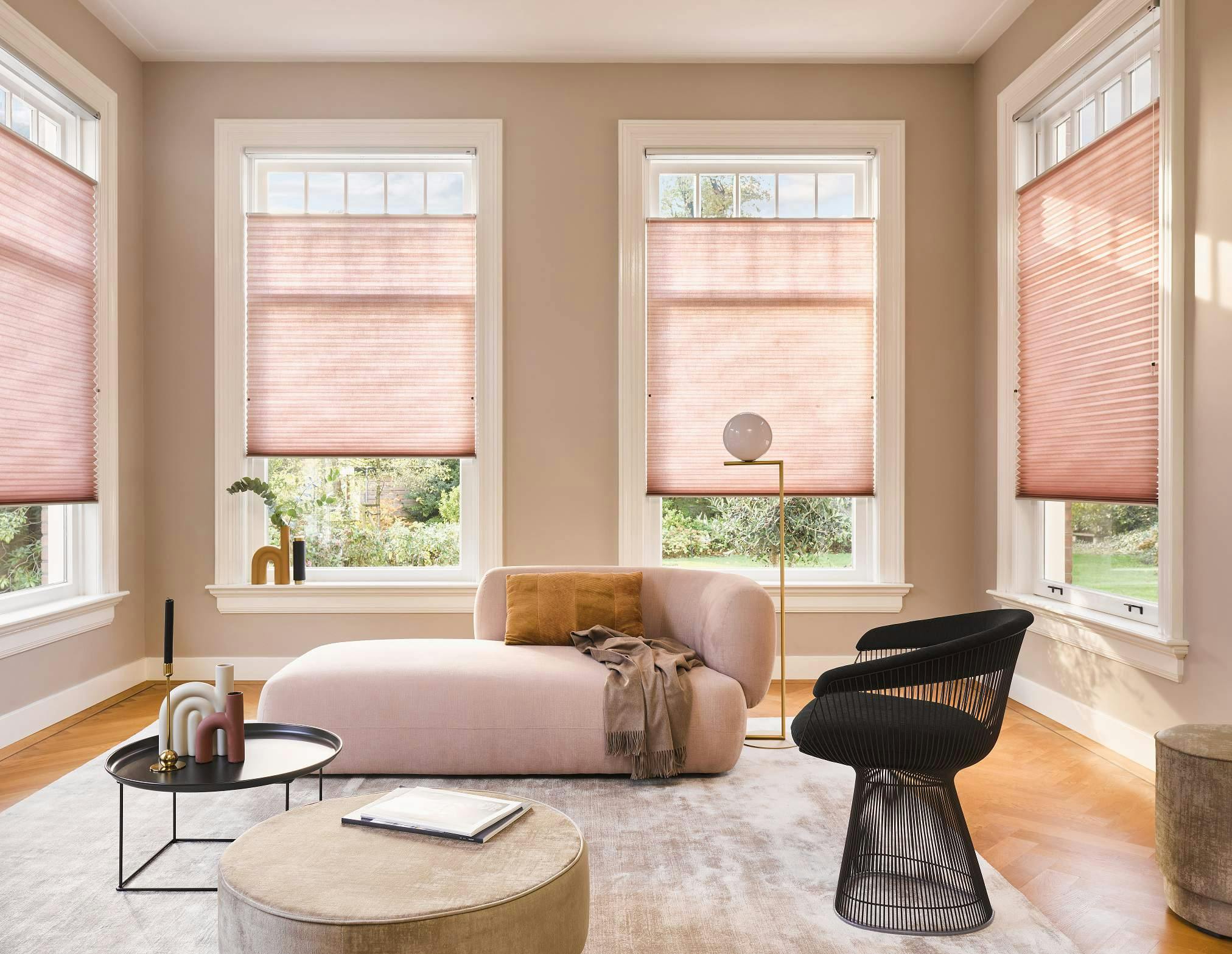 Pastel living room with light pink Duette® Shades on windows
