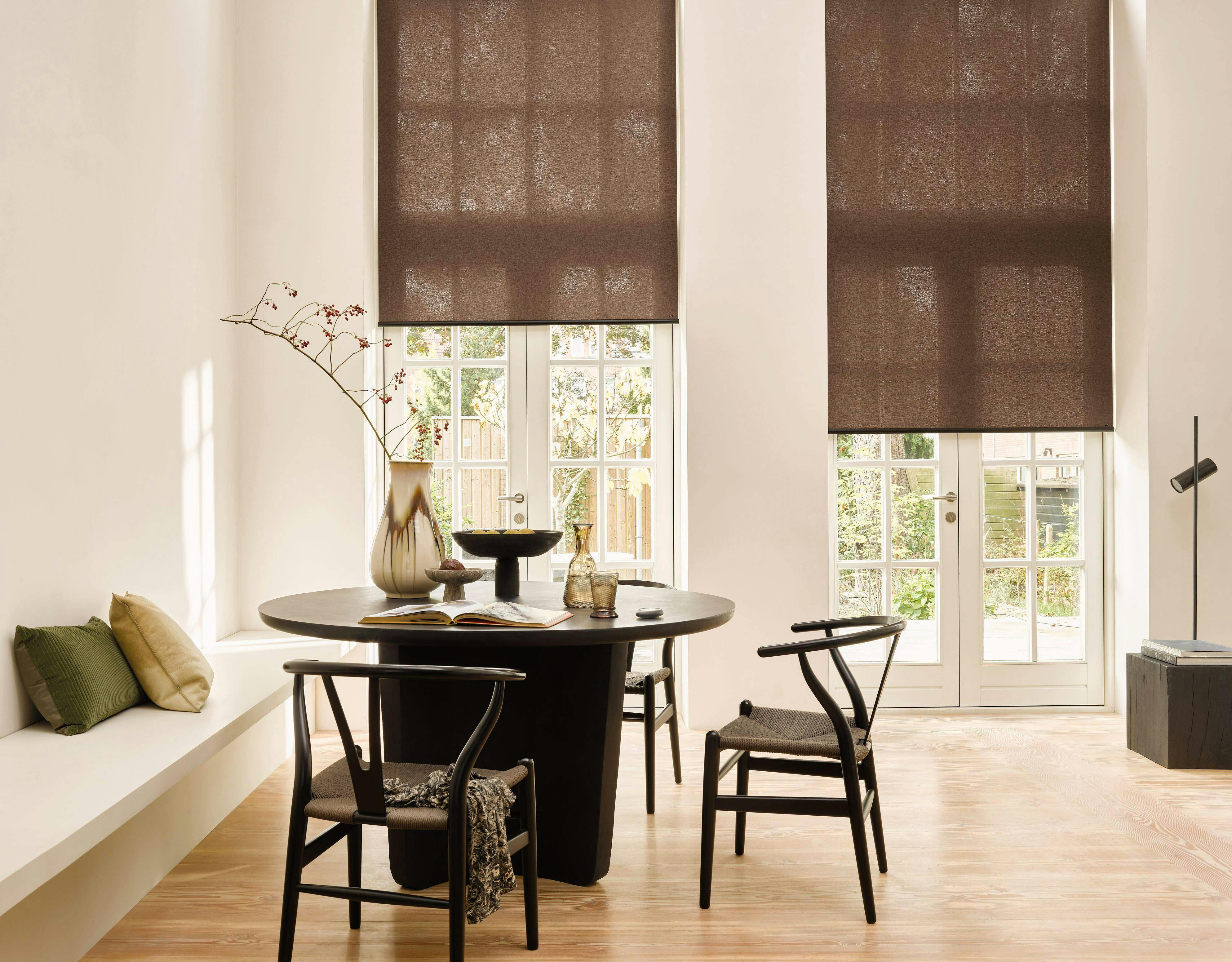 Modern living room with brown Roller blinds on a window and patio door