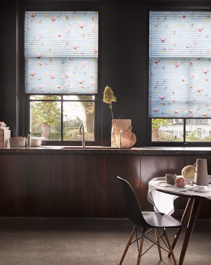 Kitchen with light blue patterned Plissé shades on windows