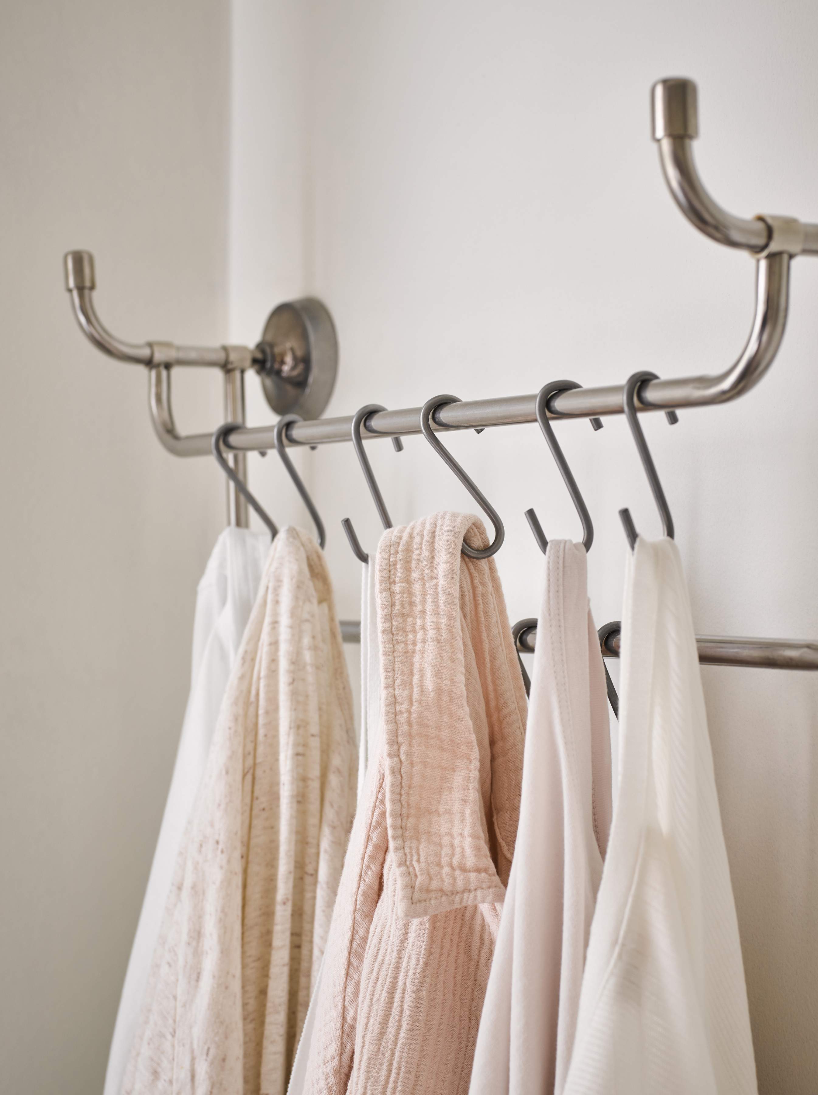 Pastel coloured bathrobes hanging in bathroom
