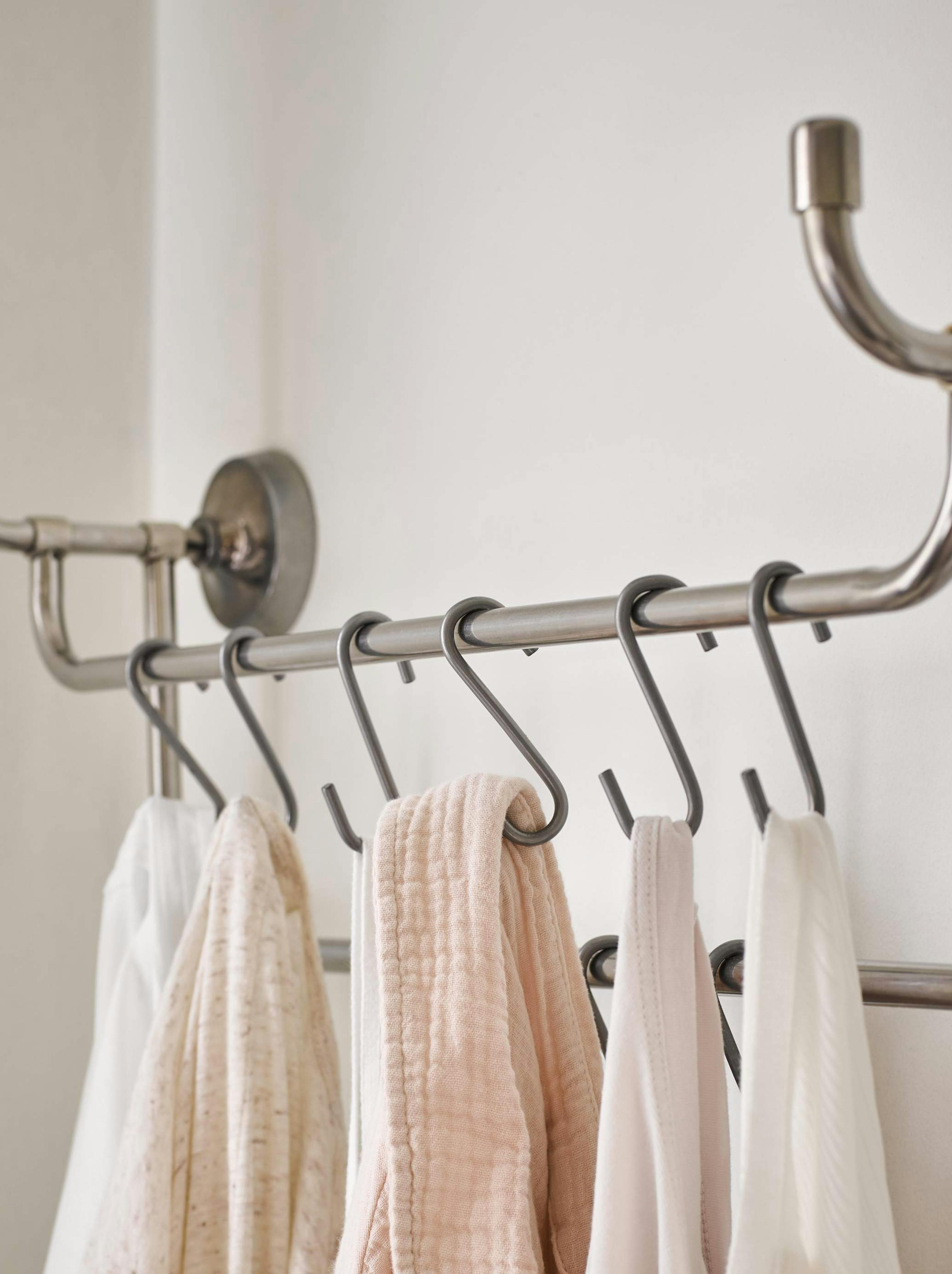 Pastel coloured bathrobes hanging in bathroom