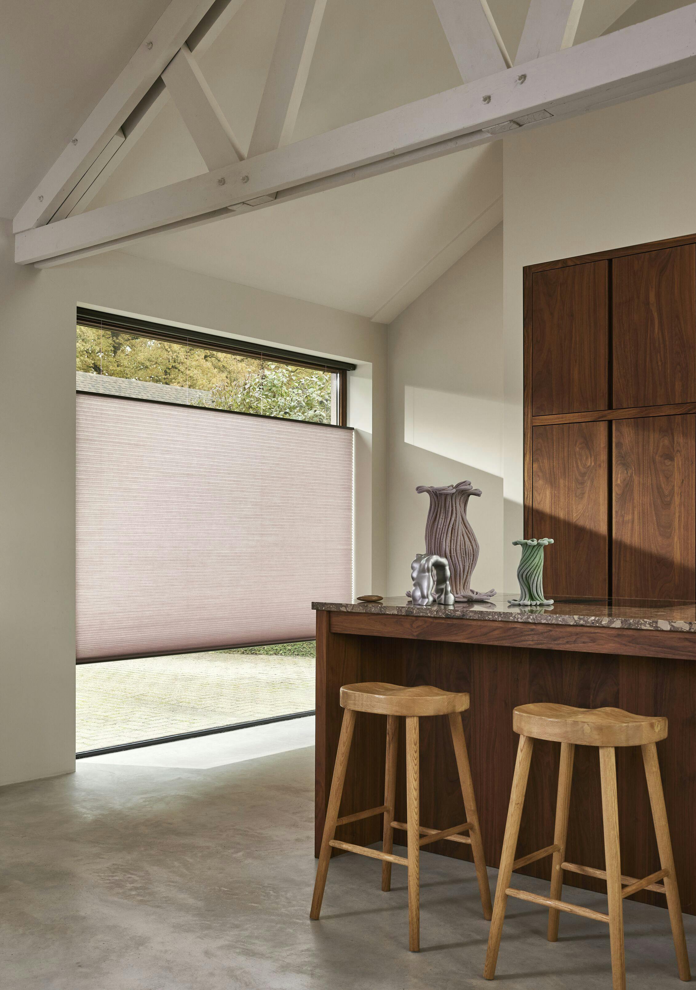 Modern kitchen with pink Duette® shades on a large window