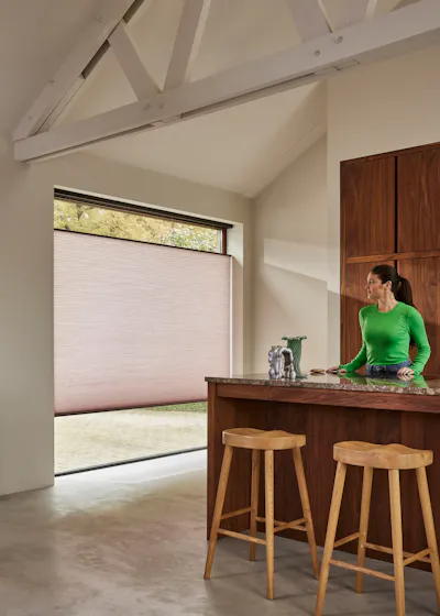 Lichtroze Duette® shades op een keukenraam