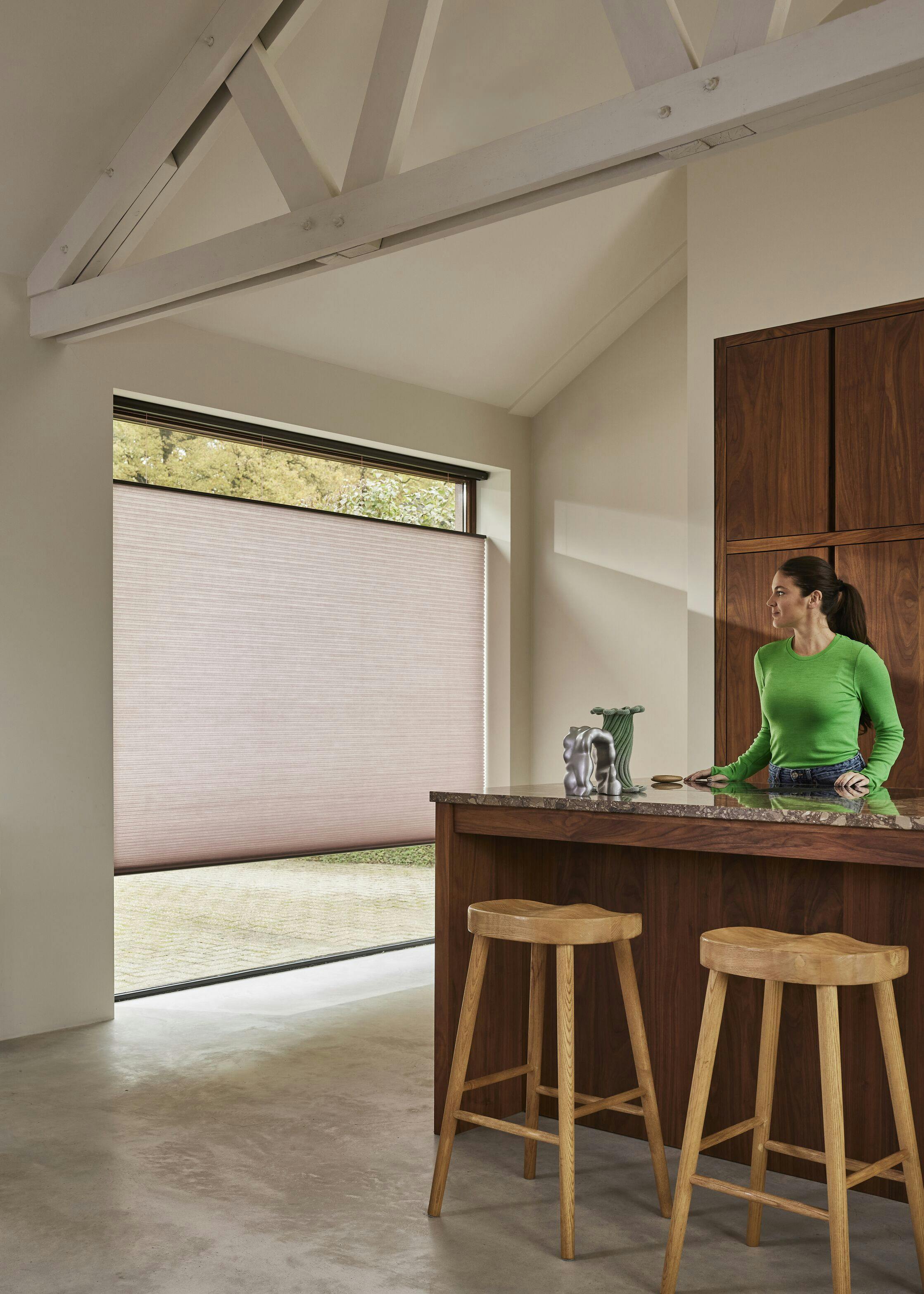 Lichtroze Duette® shades op een keukenraam