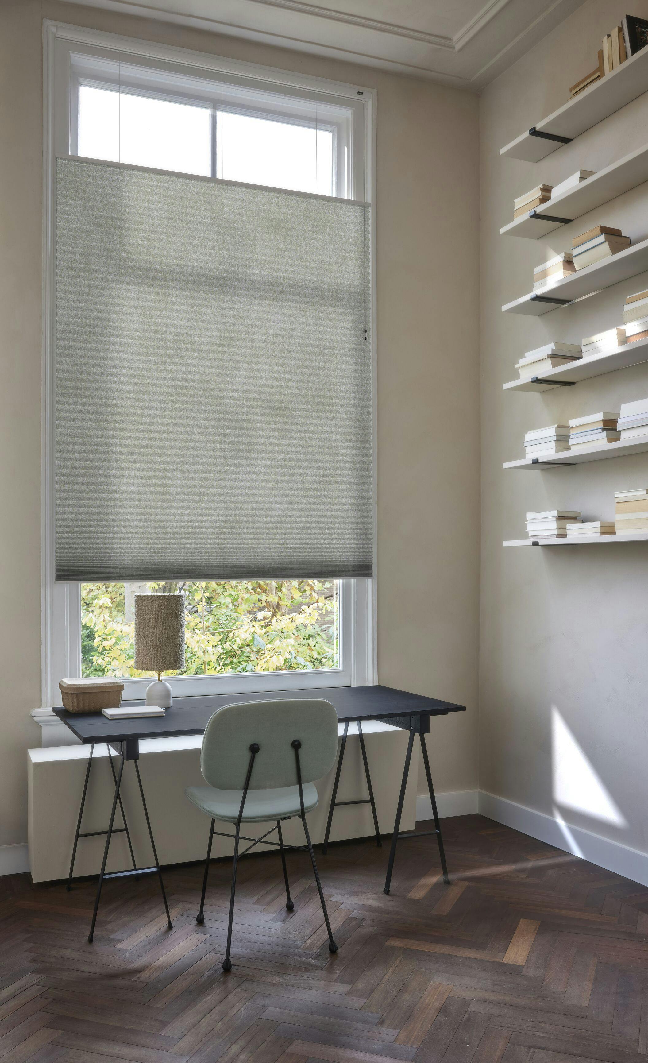 Light green Duette® blinds on a window in a cosy home office