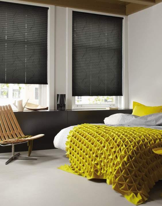 Bright bedroom with dark grey Plissé shades on windows