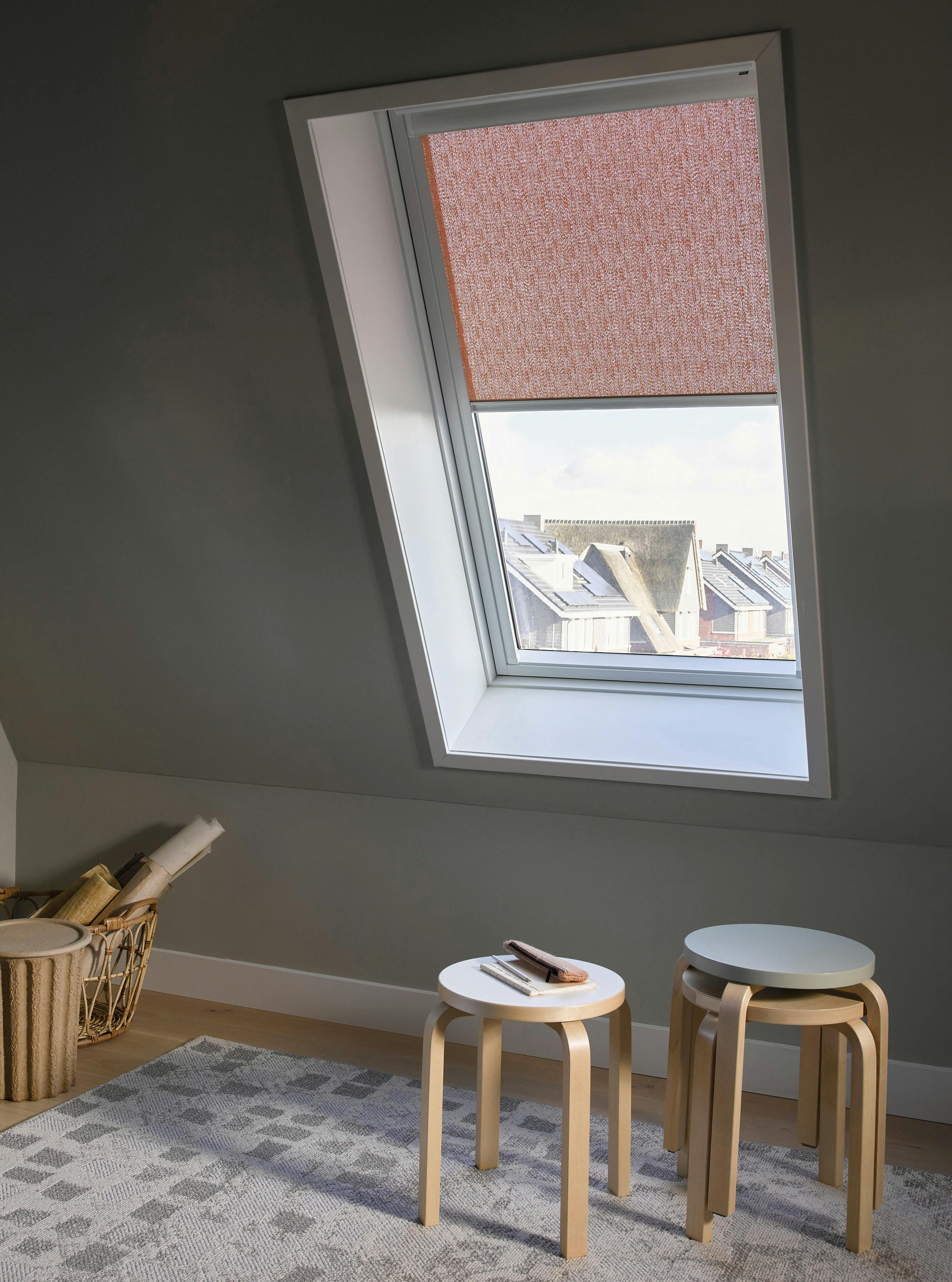 Half geopende roze rolgordijnen op een raam