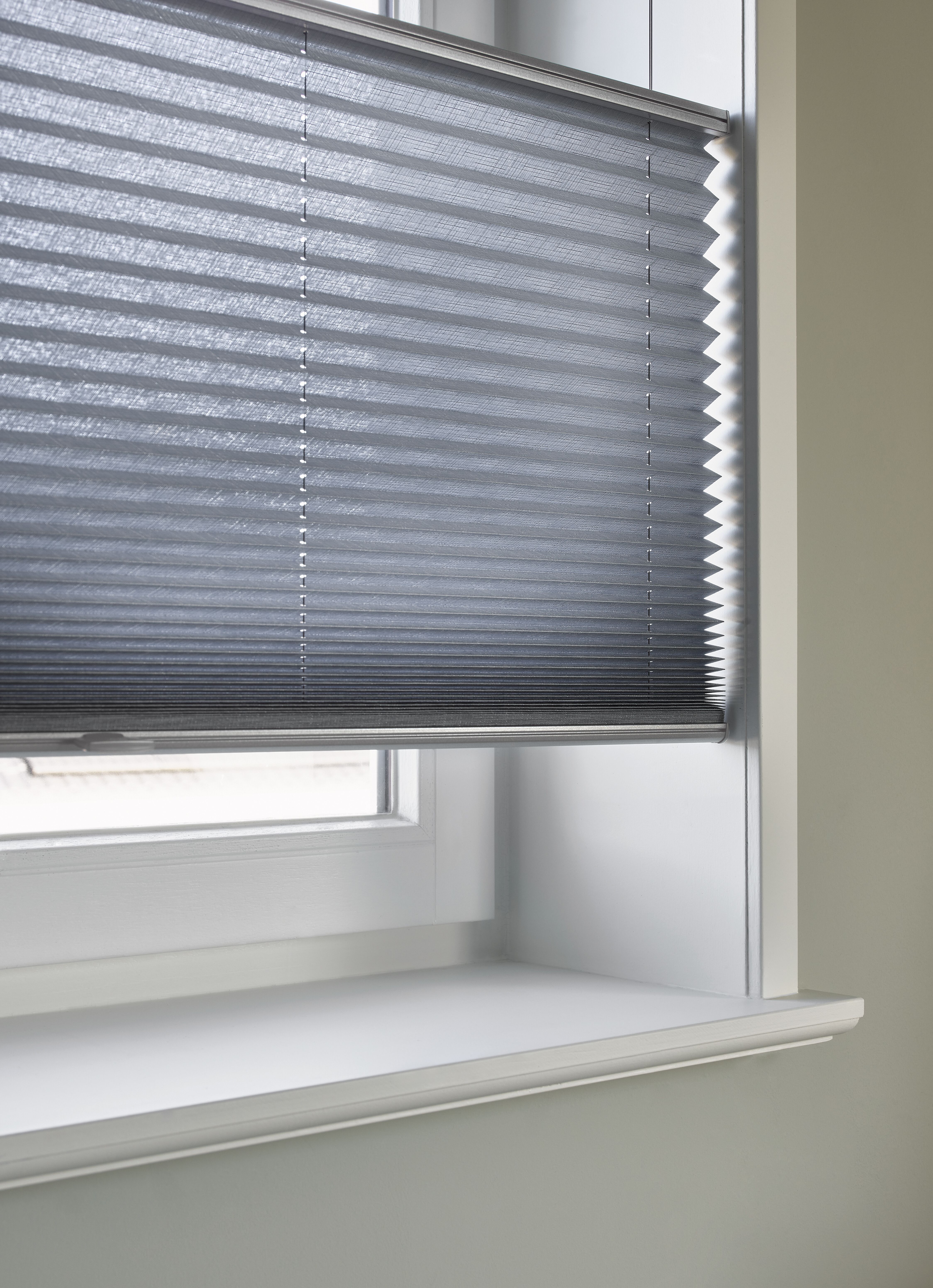 Close-up van blauwe plissé shades met top down/bottom up-functie