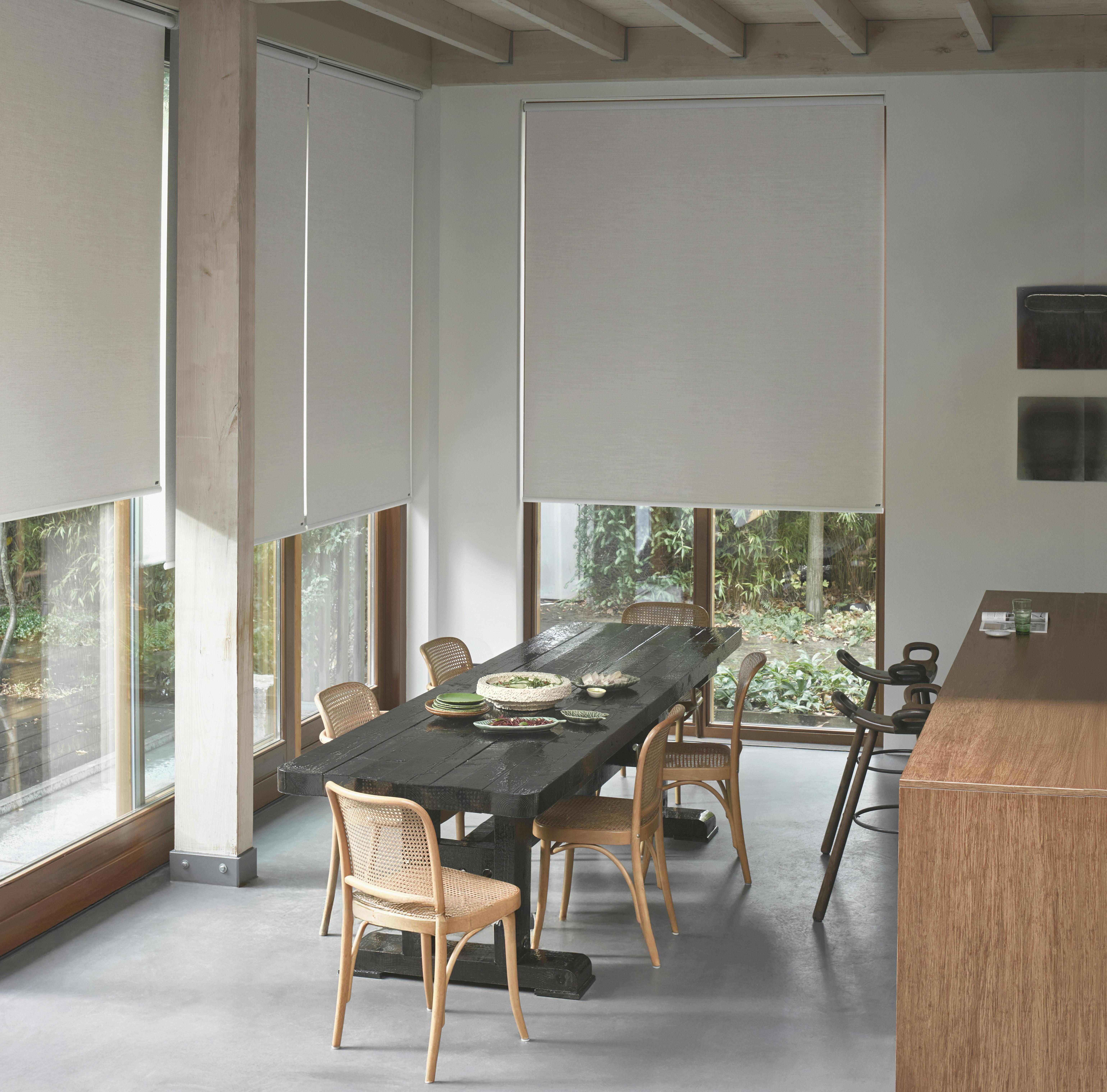 Spacious kitchen with white roller blinds on large windows