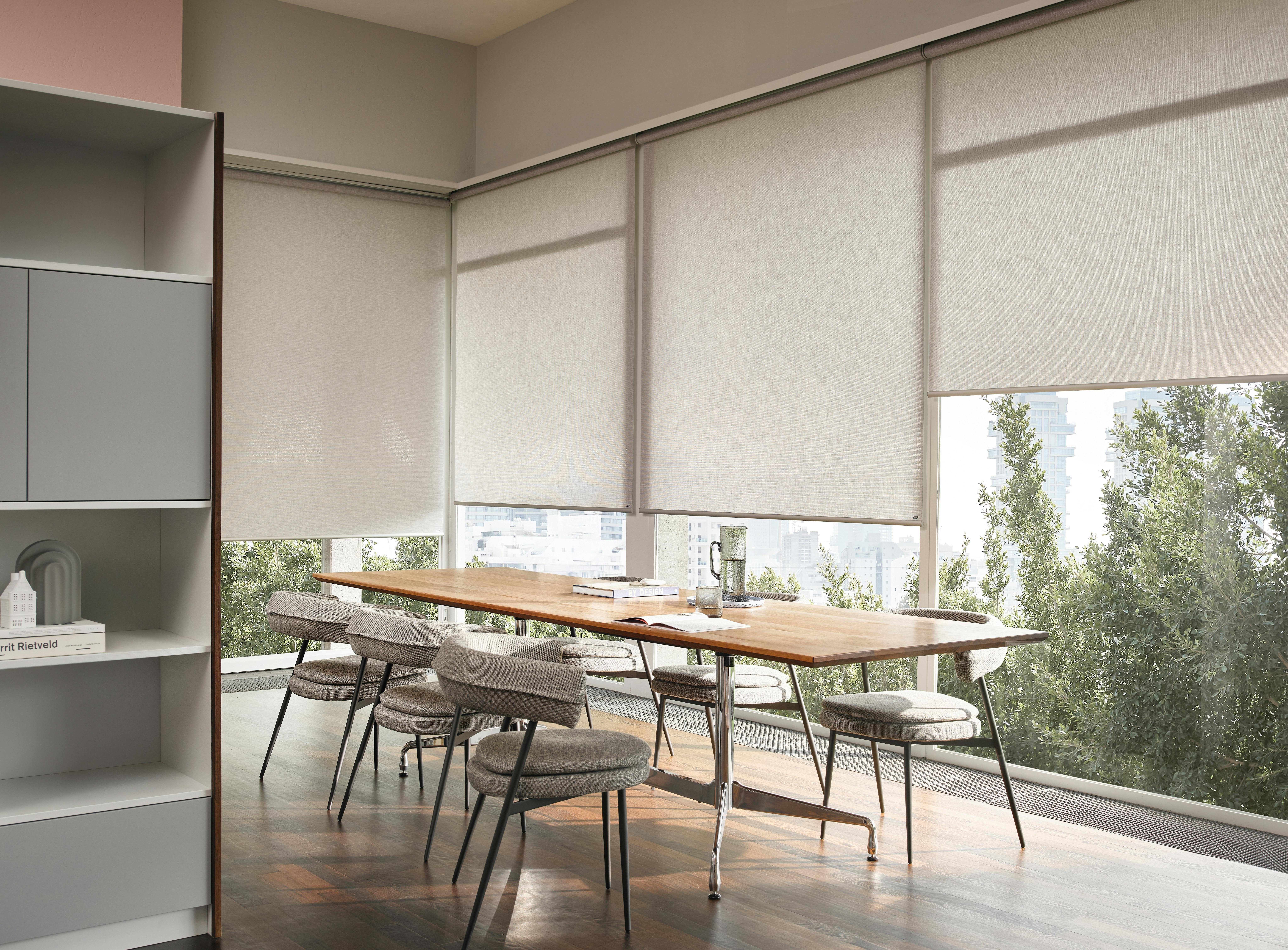 Spacious kitchen with cream roller blinds on large windows