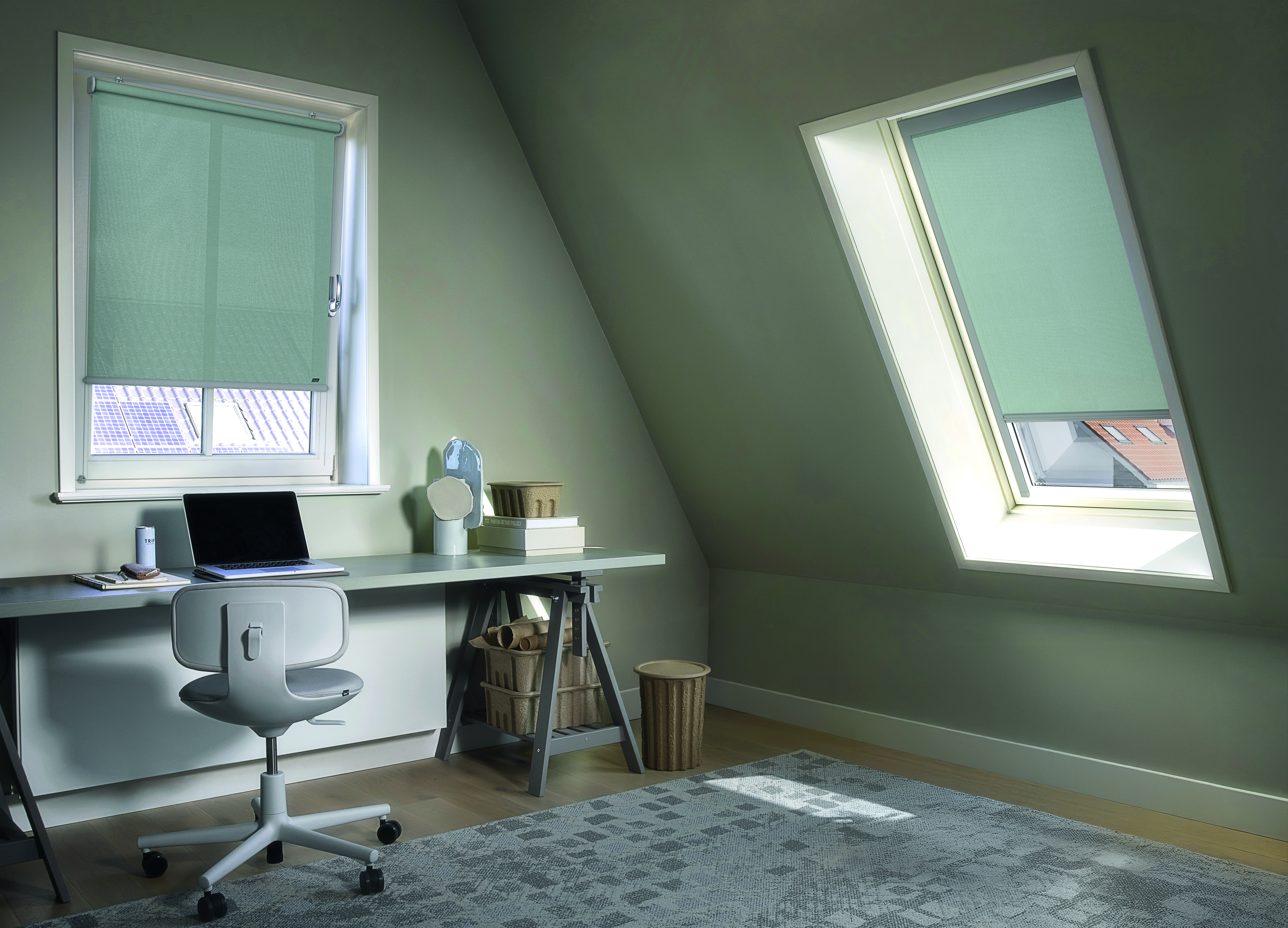 Gezellige thuiswerkplek met lichtblauwe rolgordijnen op de ramen
