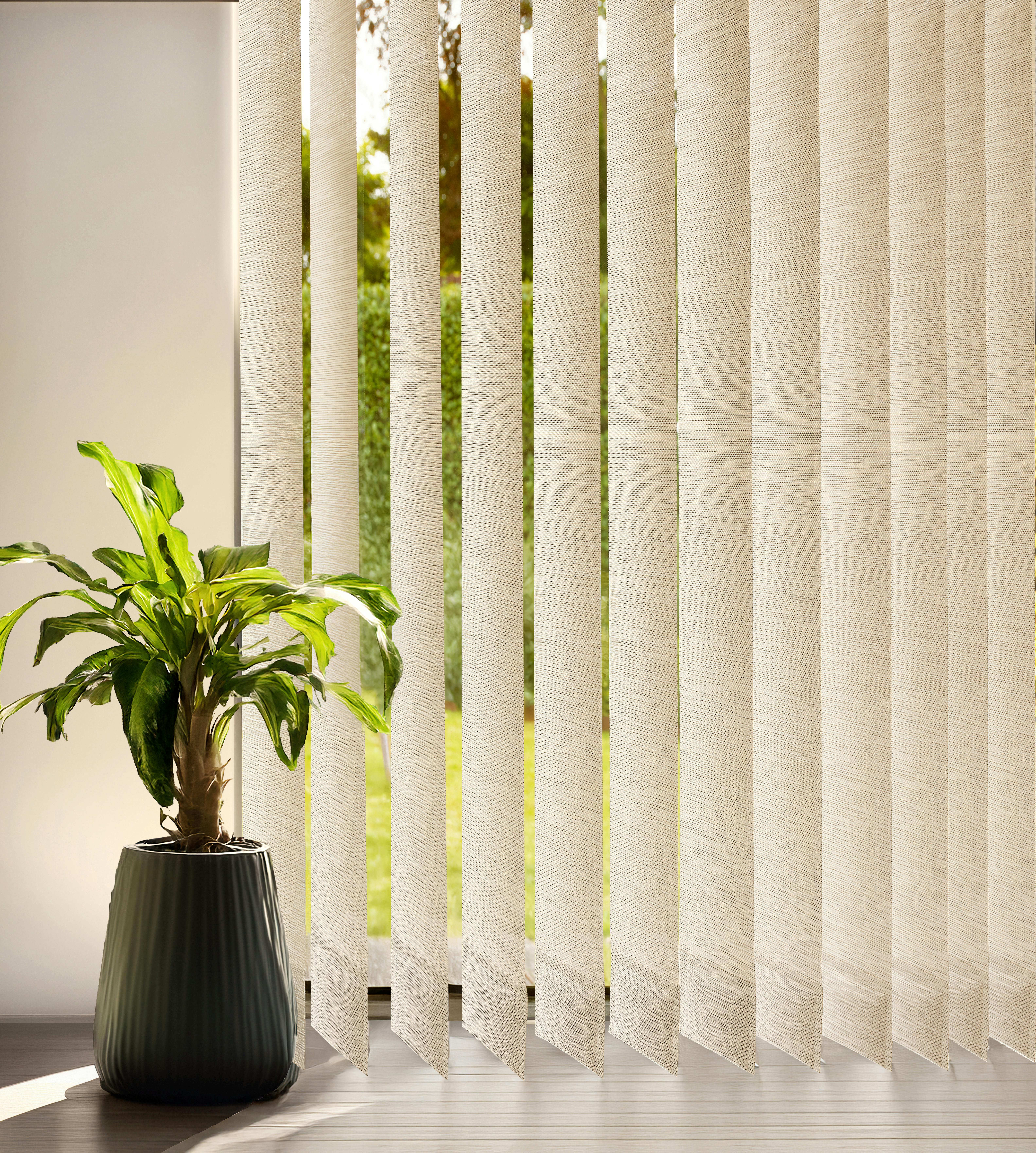 A close up of cream vertical blinds on a window and a plant next to it placed on the ground