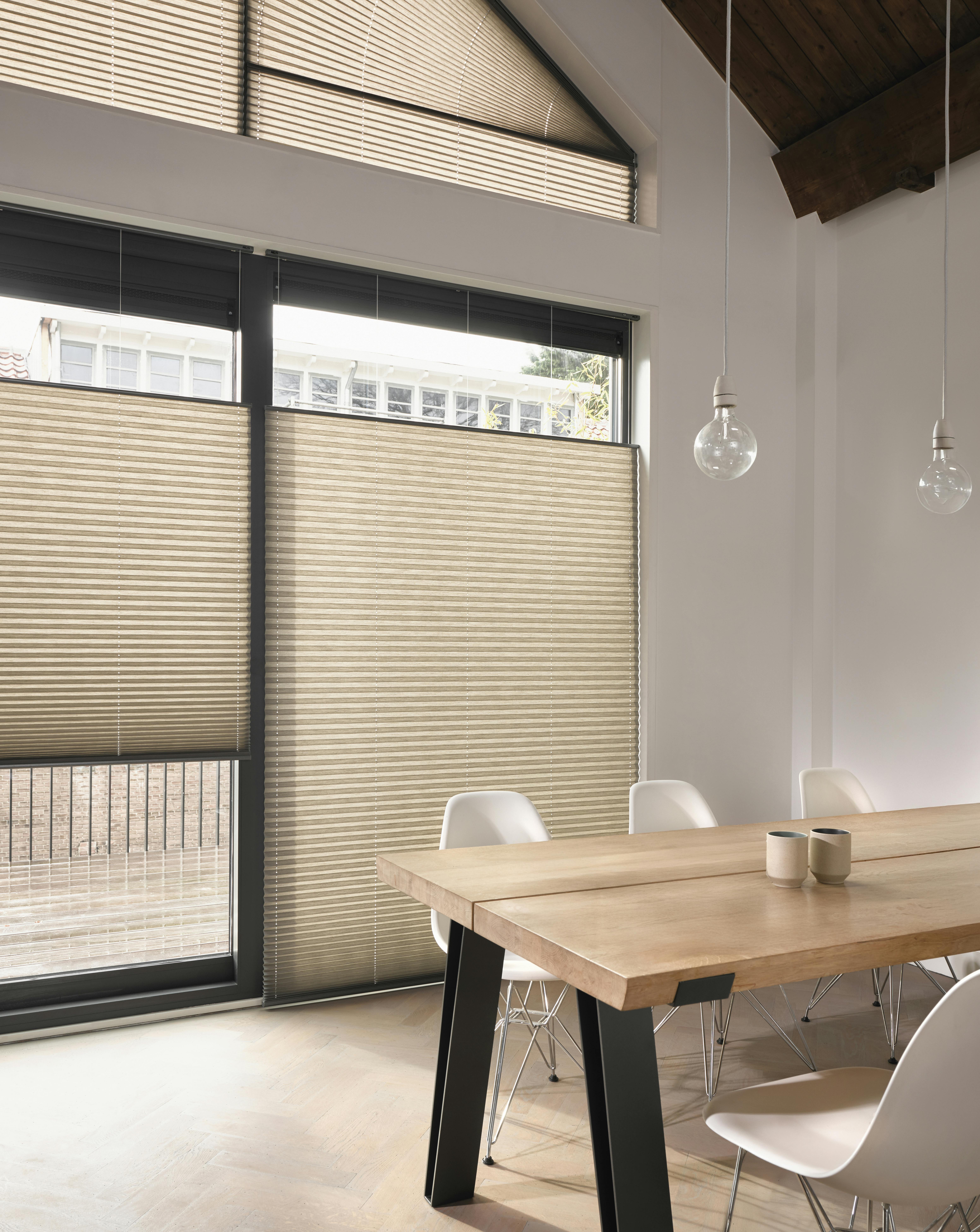Cream plisse shades in a dining room window 