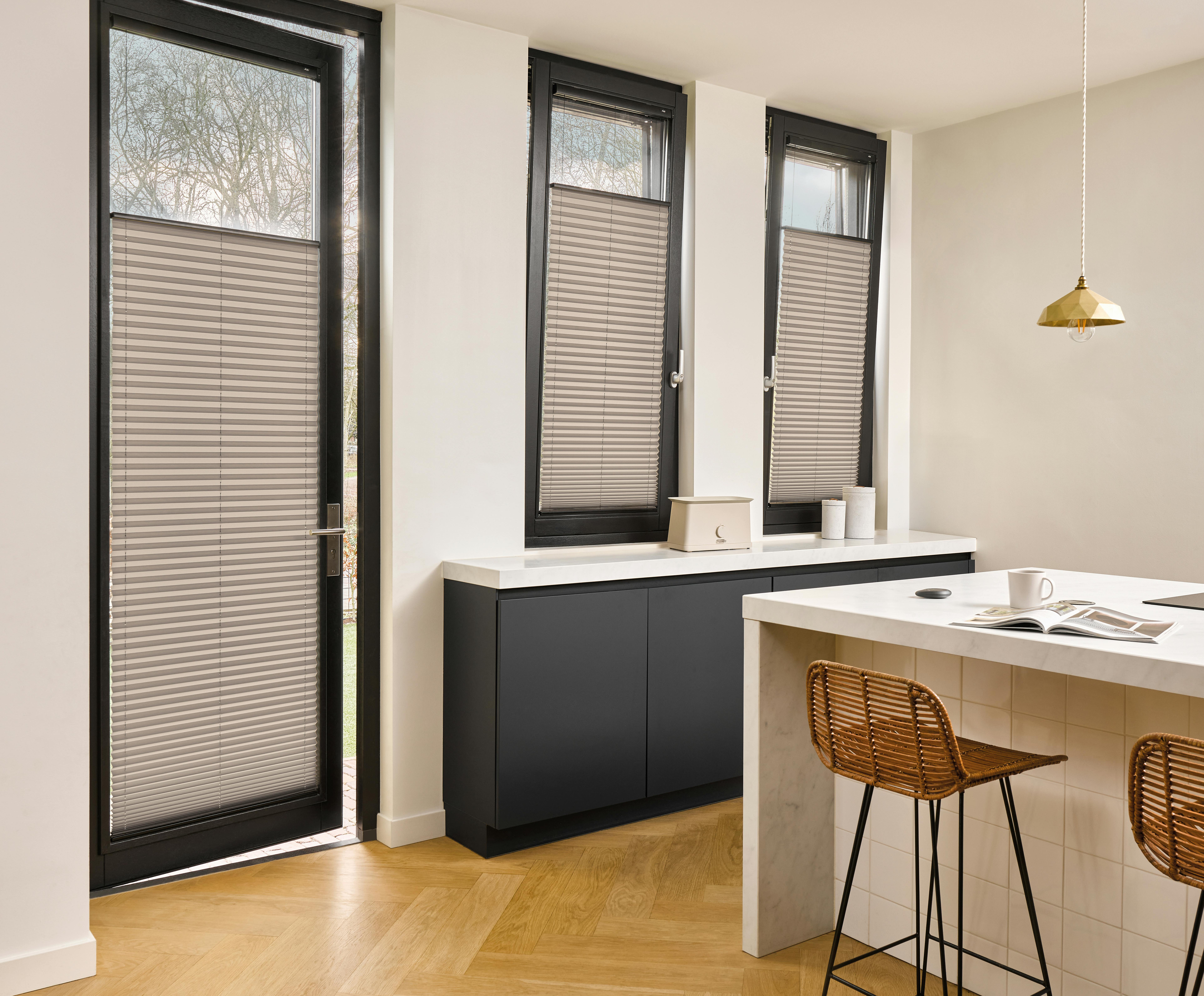 Grey plisse shades on door and windows in a kitchen 