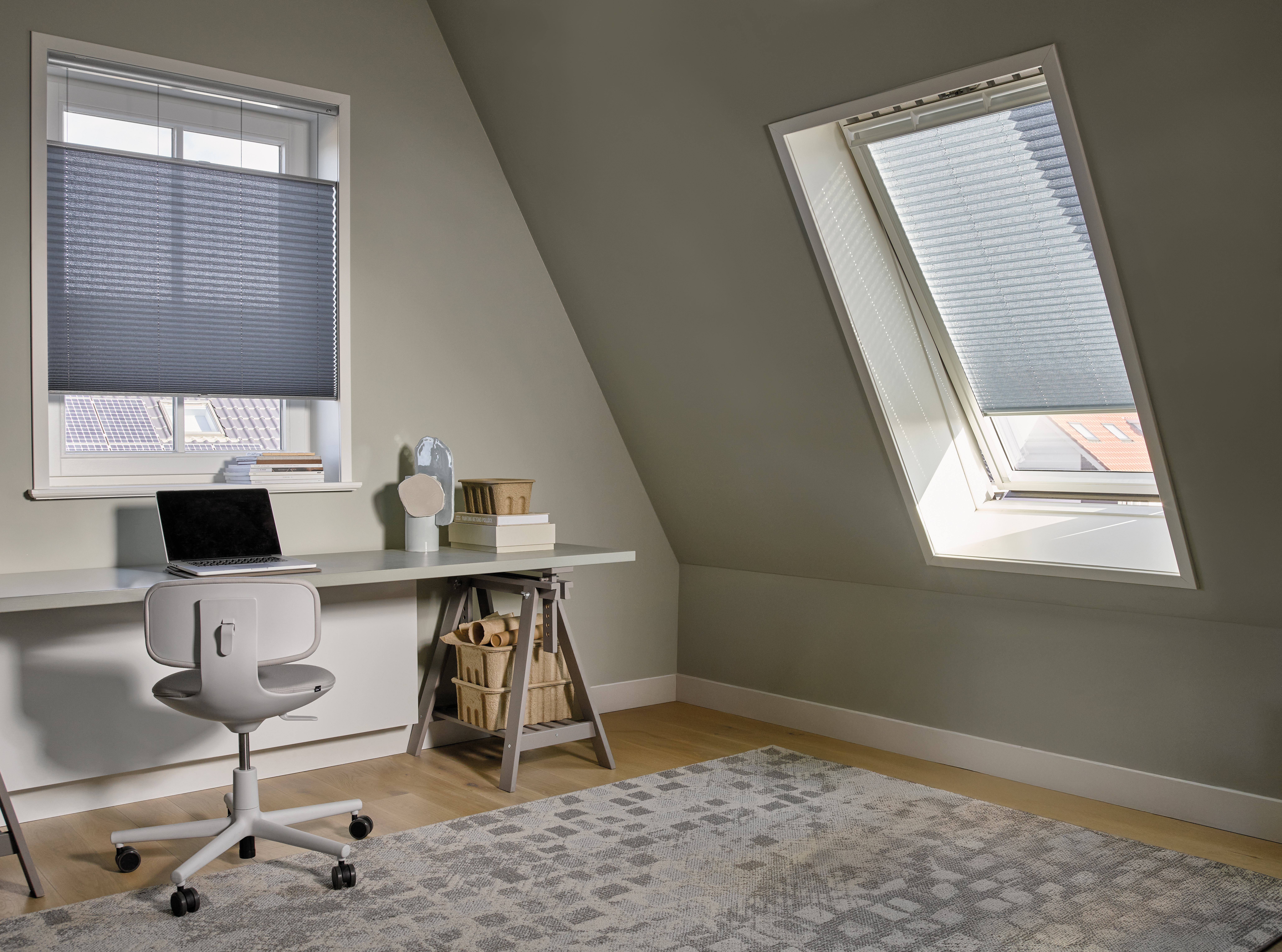 Blauwe plissé shades in een standaard- en dakraam in een loft van een thuiskantoor