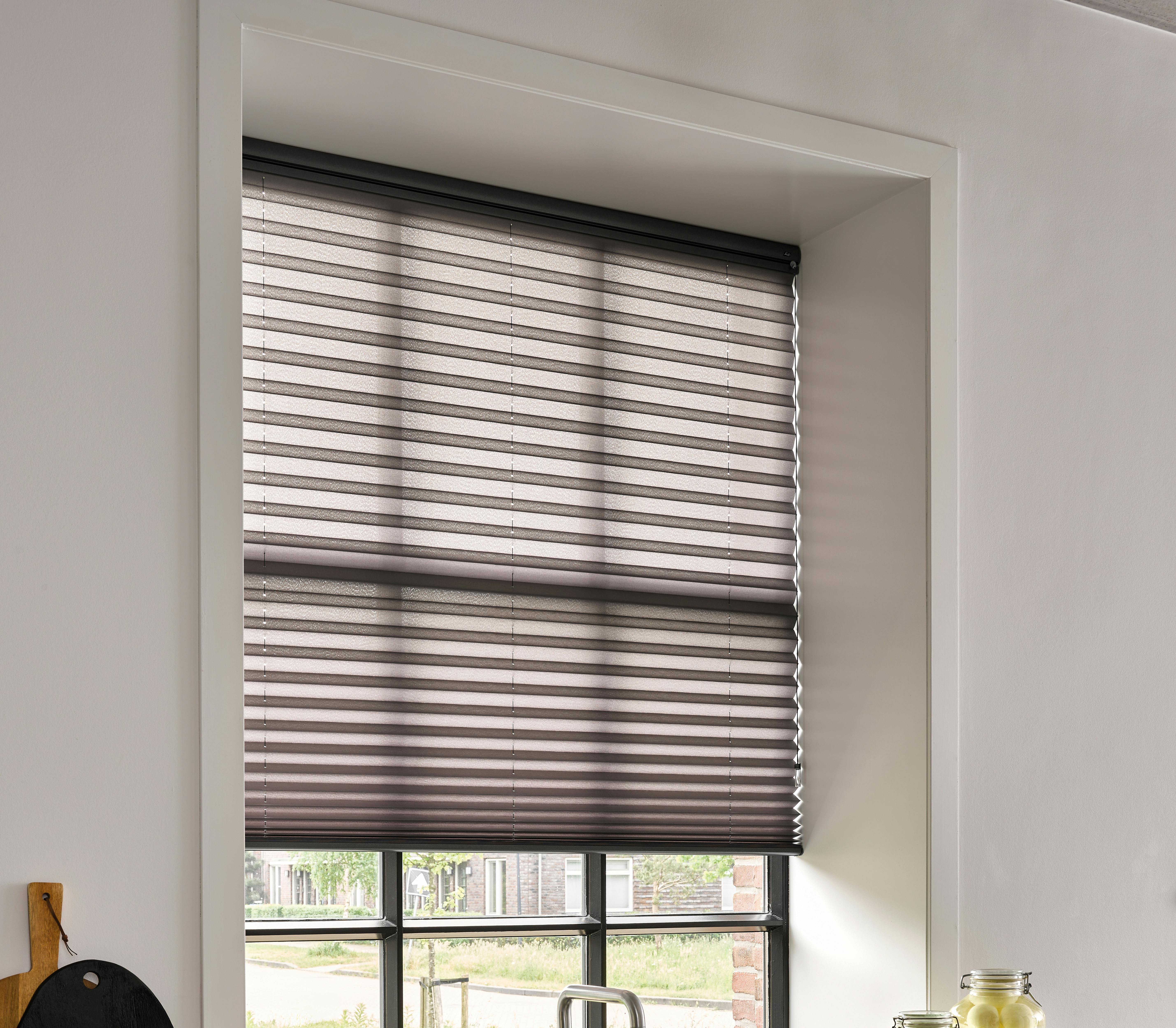 Zwarte plissé shades op een keukenraam