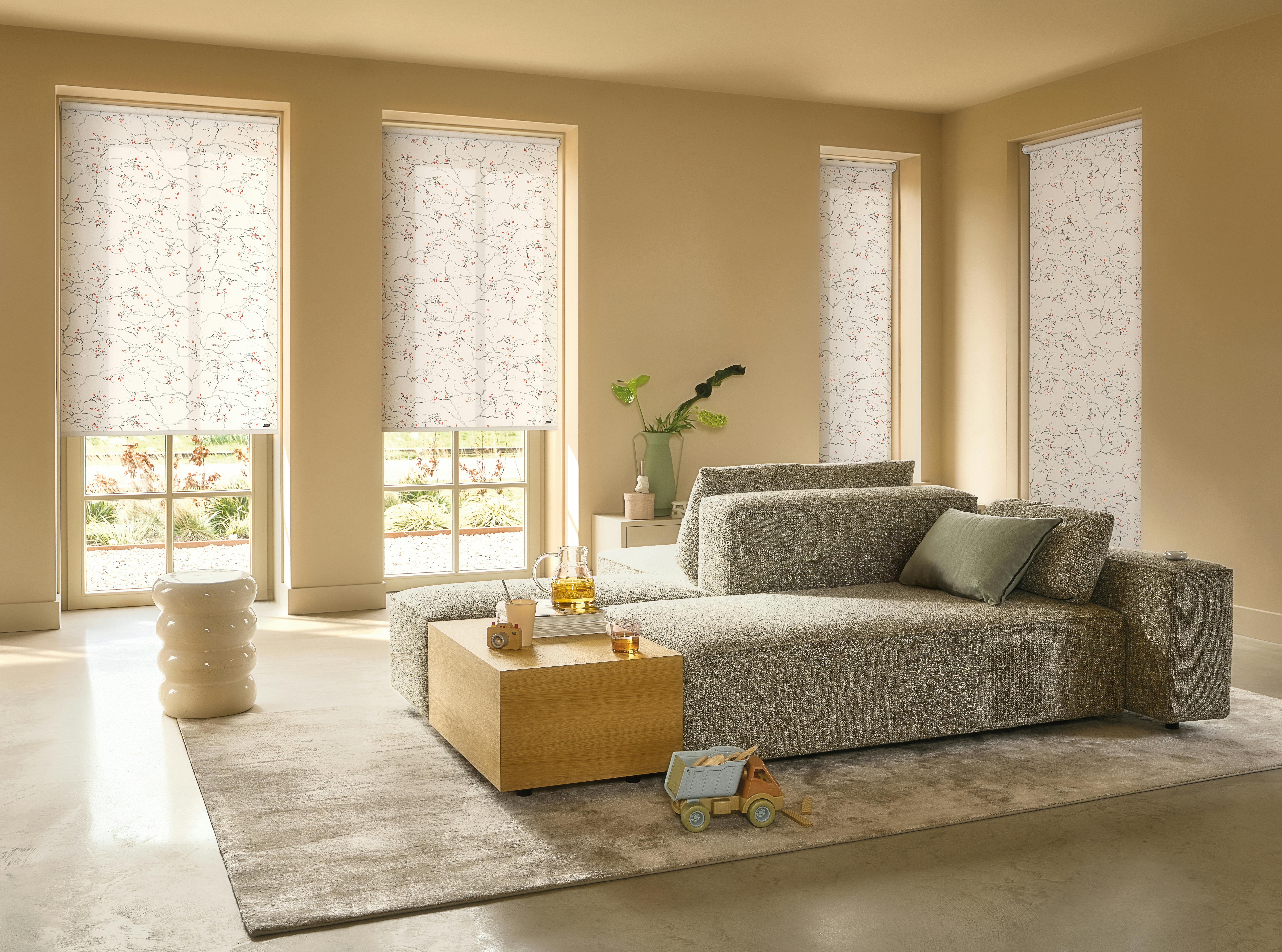 White roller blind with red and grey flower designs in a yellow living room