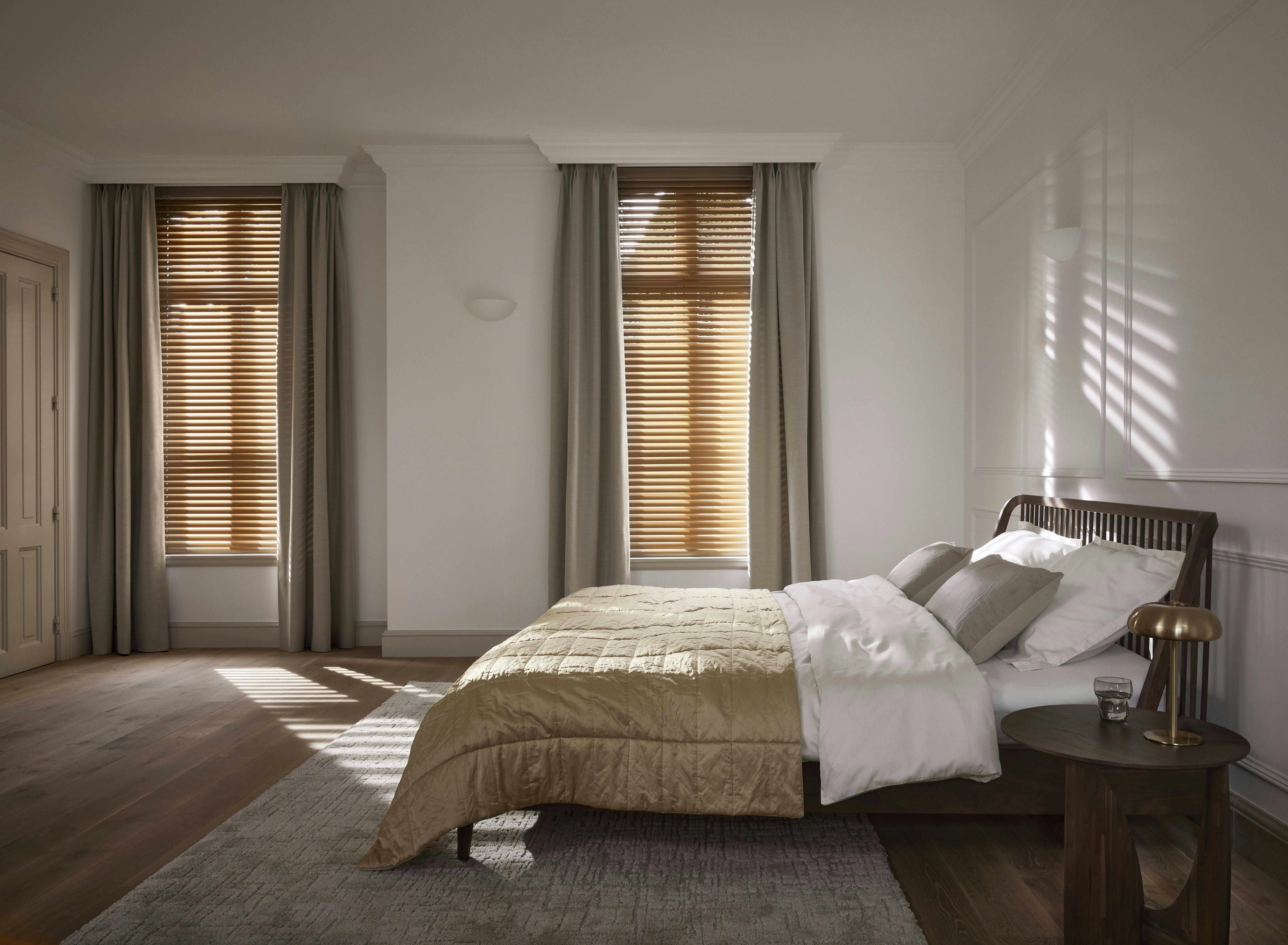 layering van praktische horizontale jaloezieën met sfeervolle verduisterende gordijnen in de slaapkamer