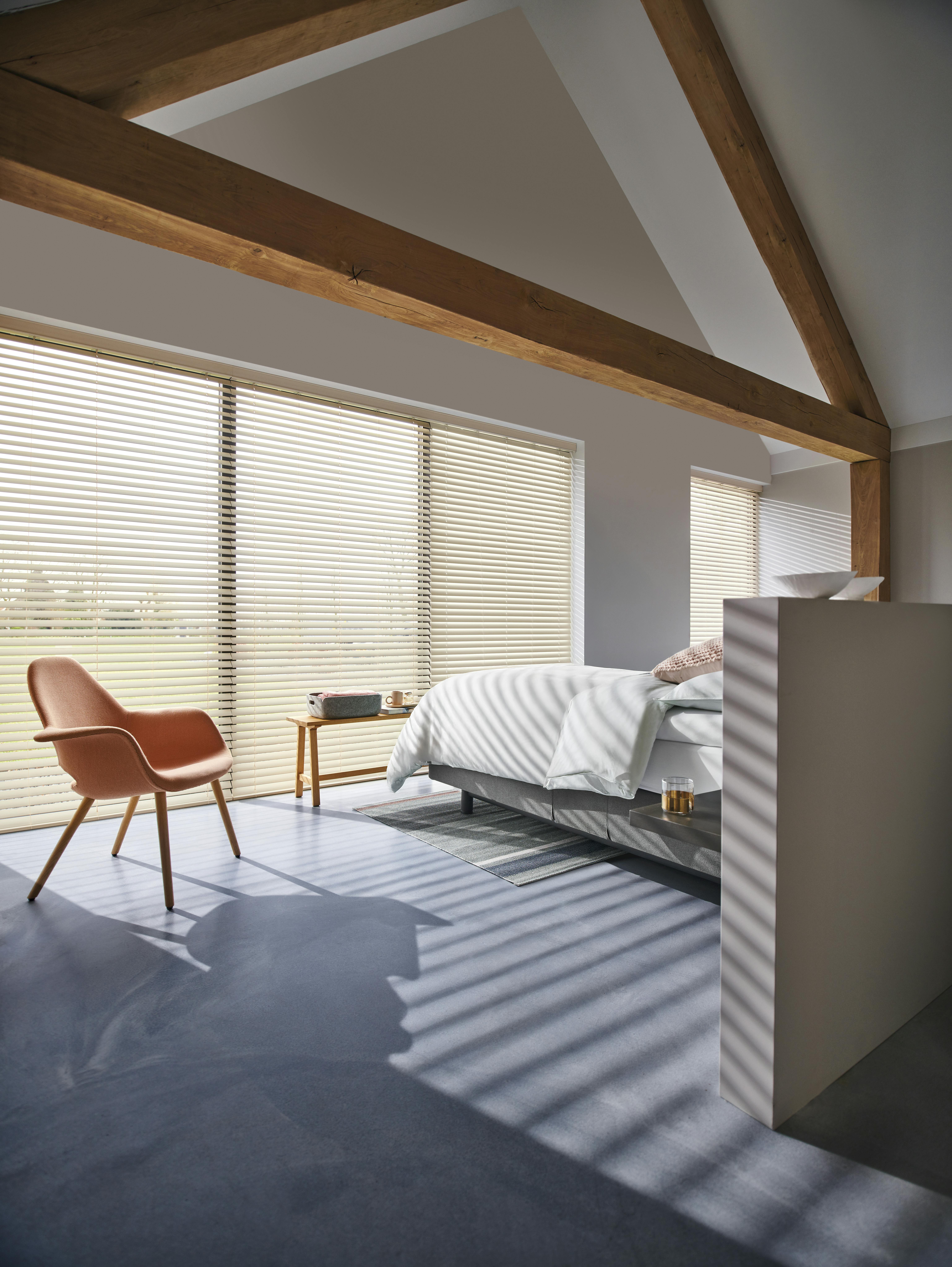 Crèmekleurige houten jaloezieën in een slaapkamer