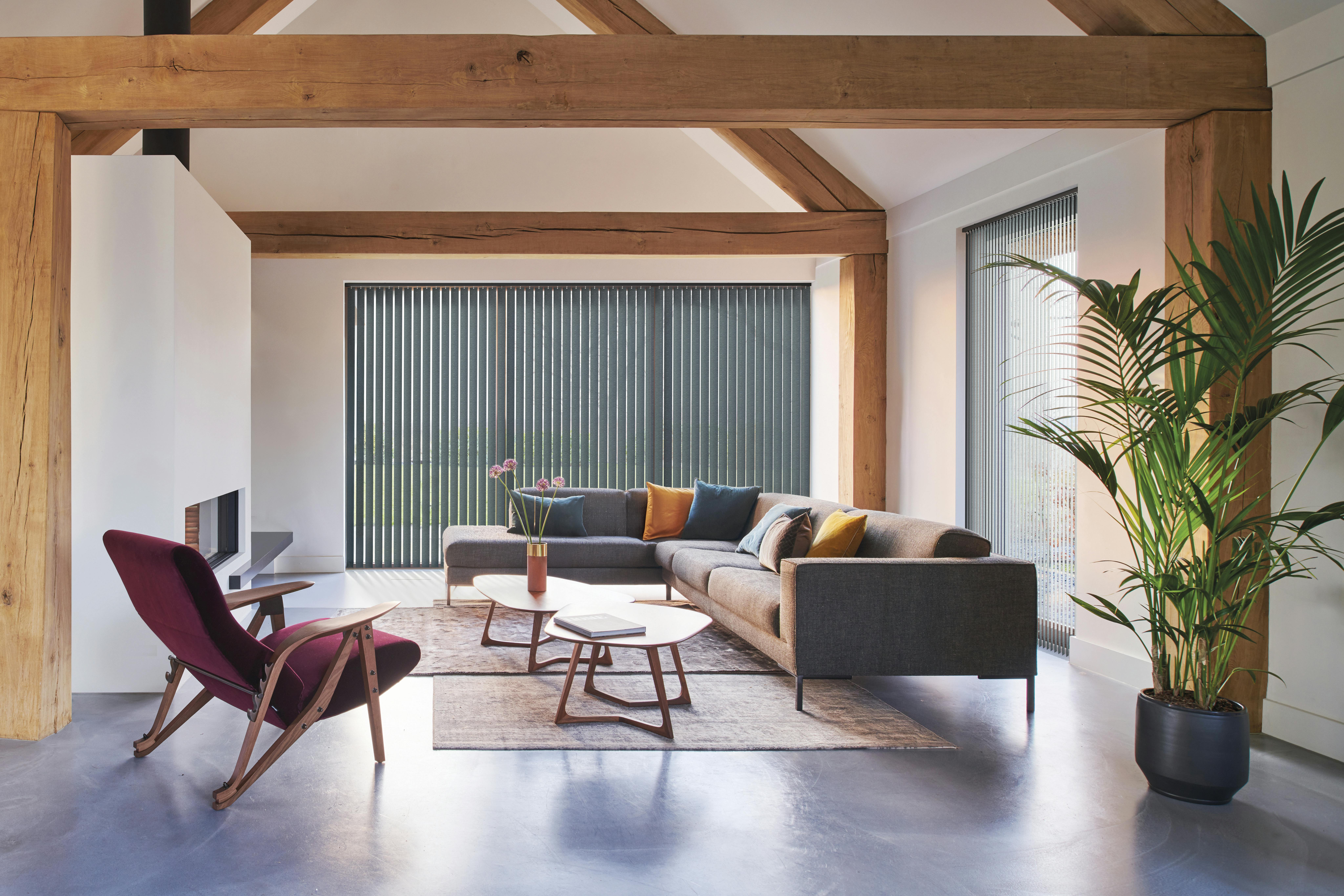 Dark blue vertical blinds on large windows in a living room 