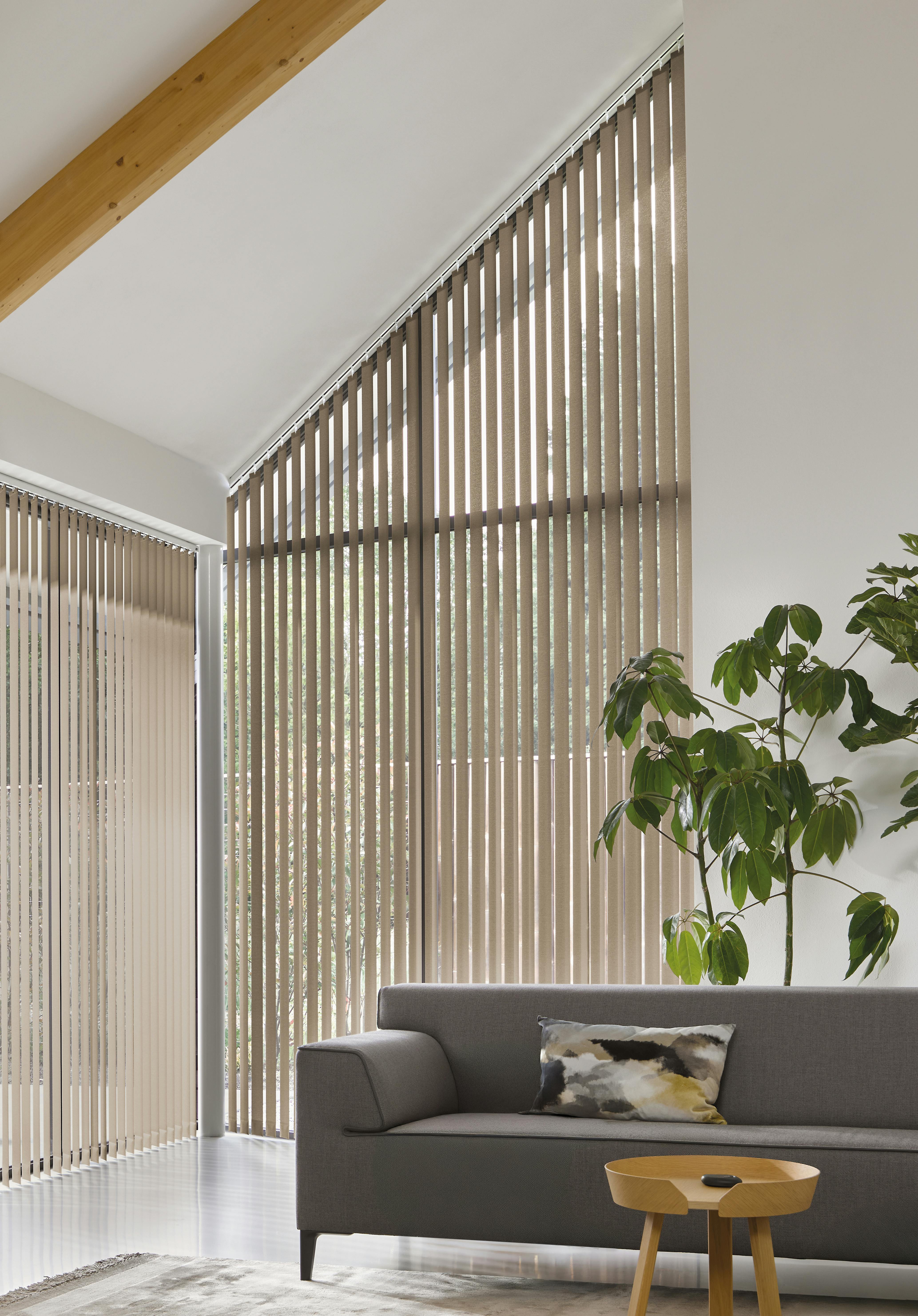 Light brown vertical blinds on a special shaped window in a spacious living room