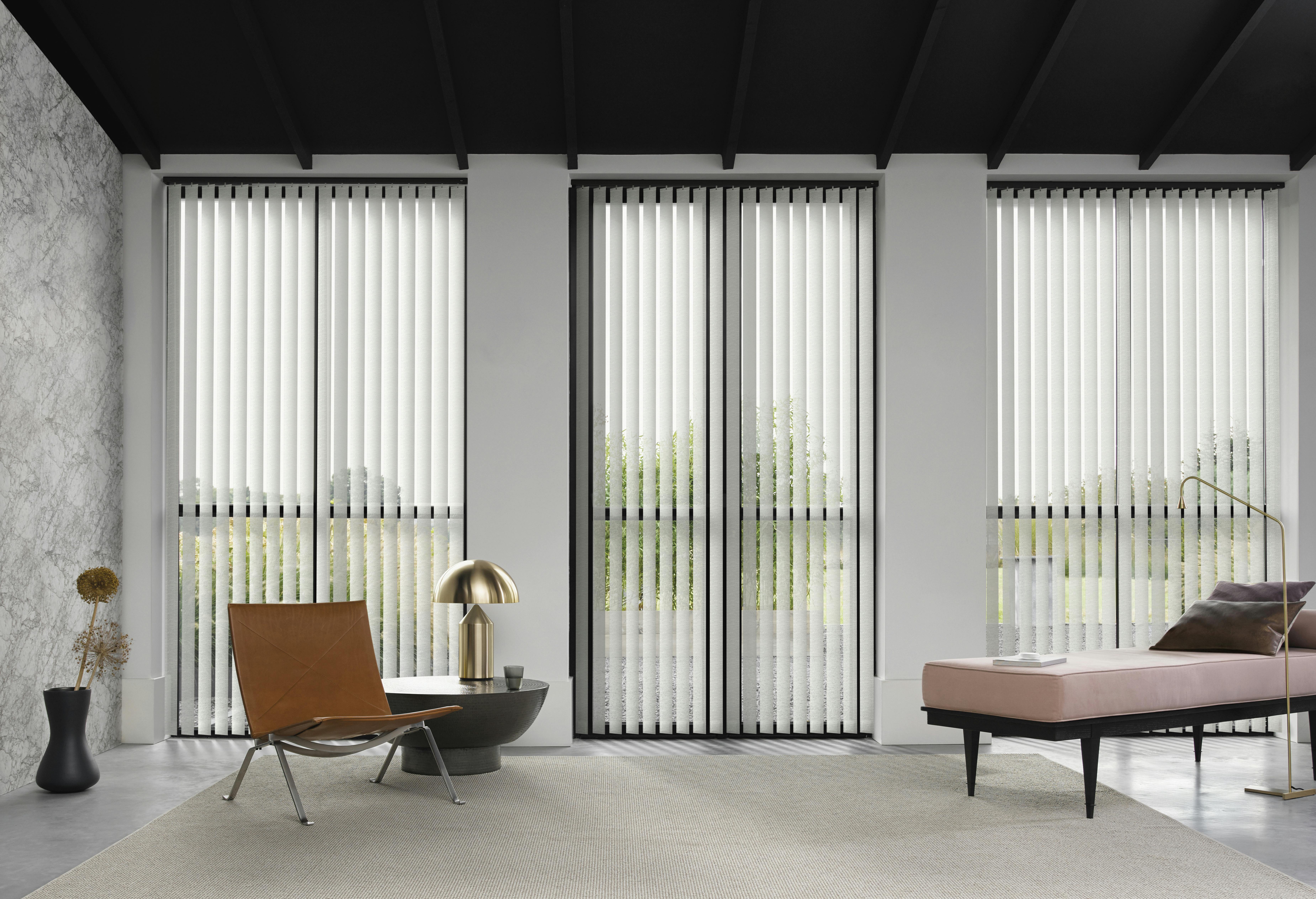 White vertical blinds on large windows in a living room