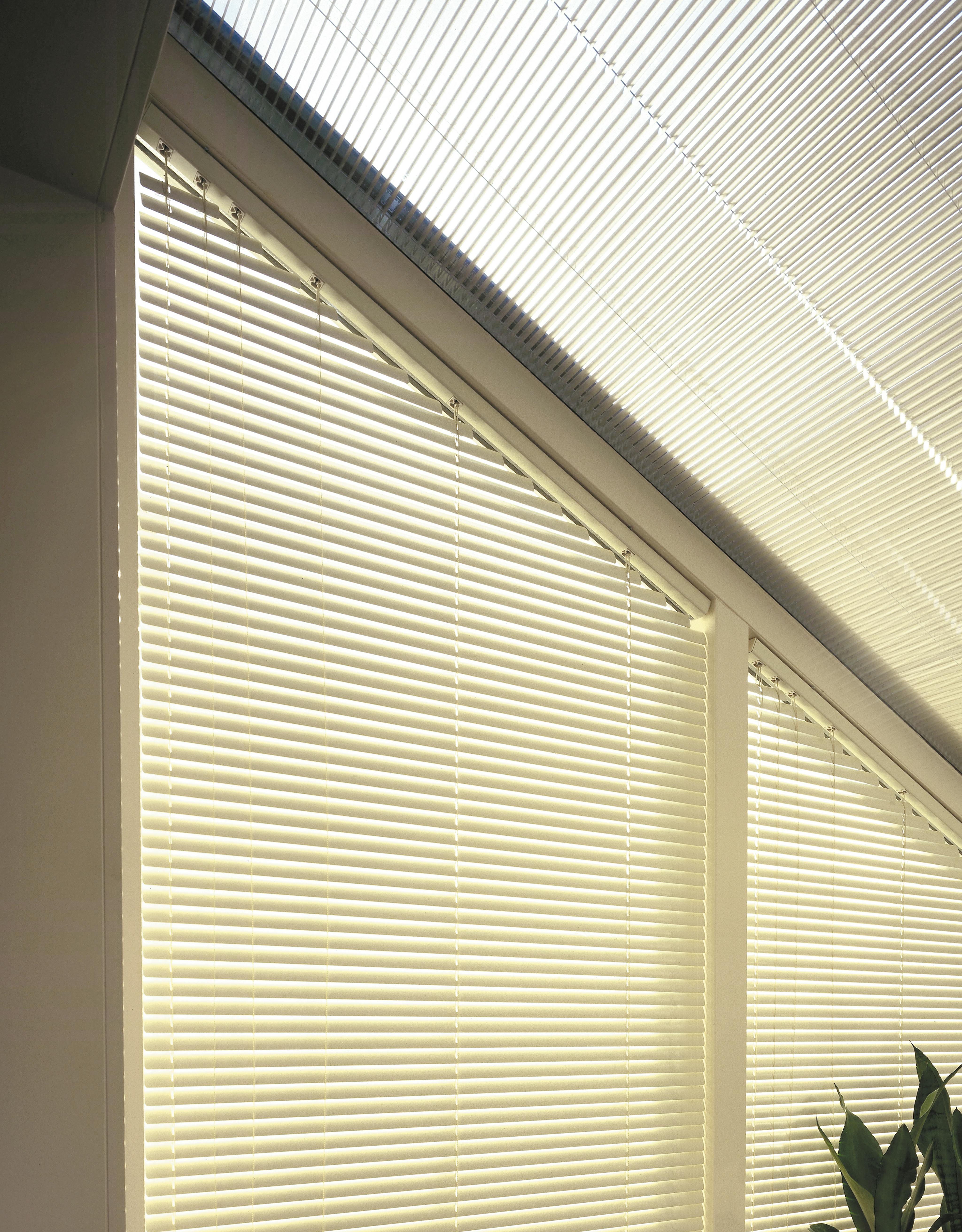 Lichtgele jaloezieën op schuine ramen