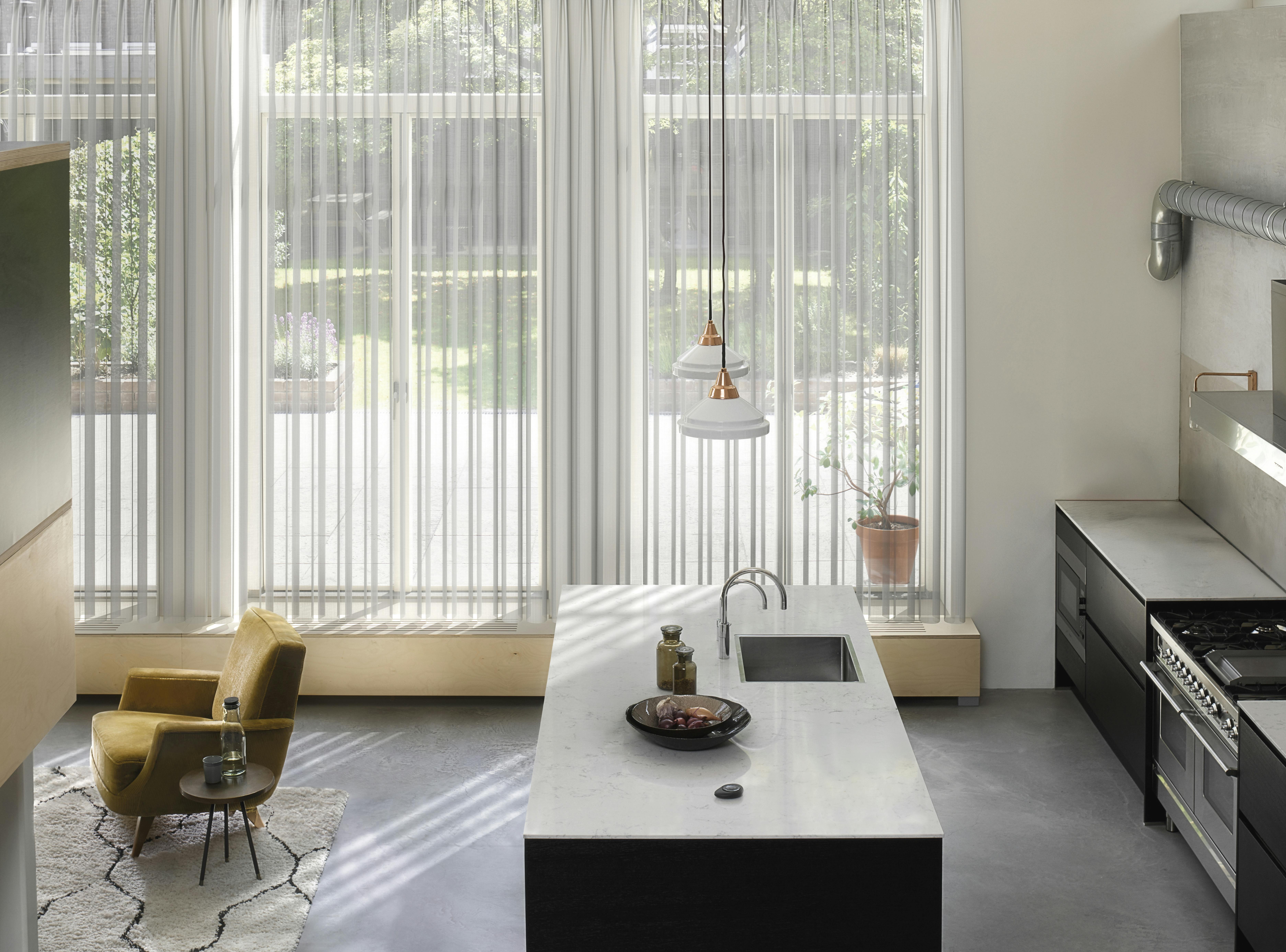 Witte gordijnen op grote ramen in een lichte keuken