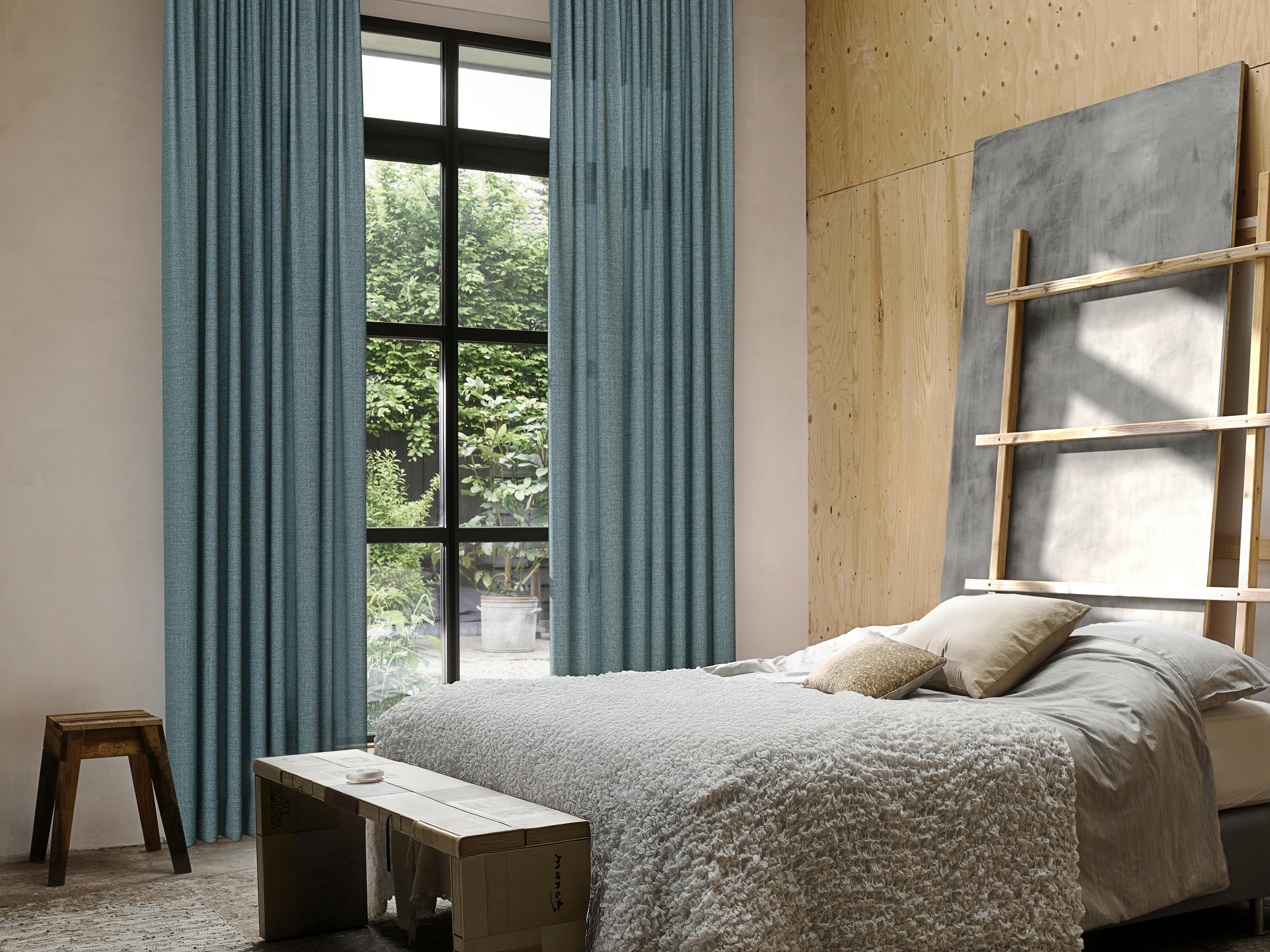 Light blue curtains on a window in a modern bedroom