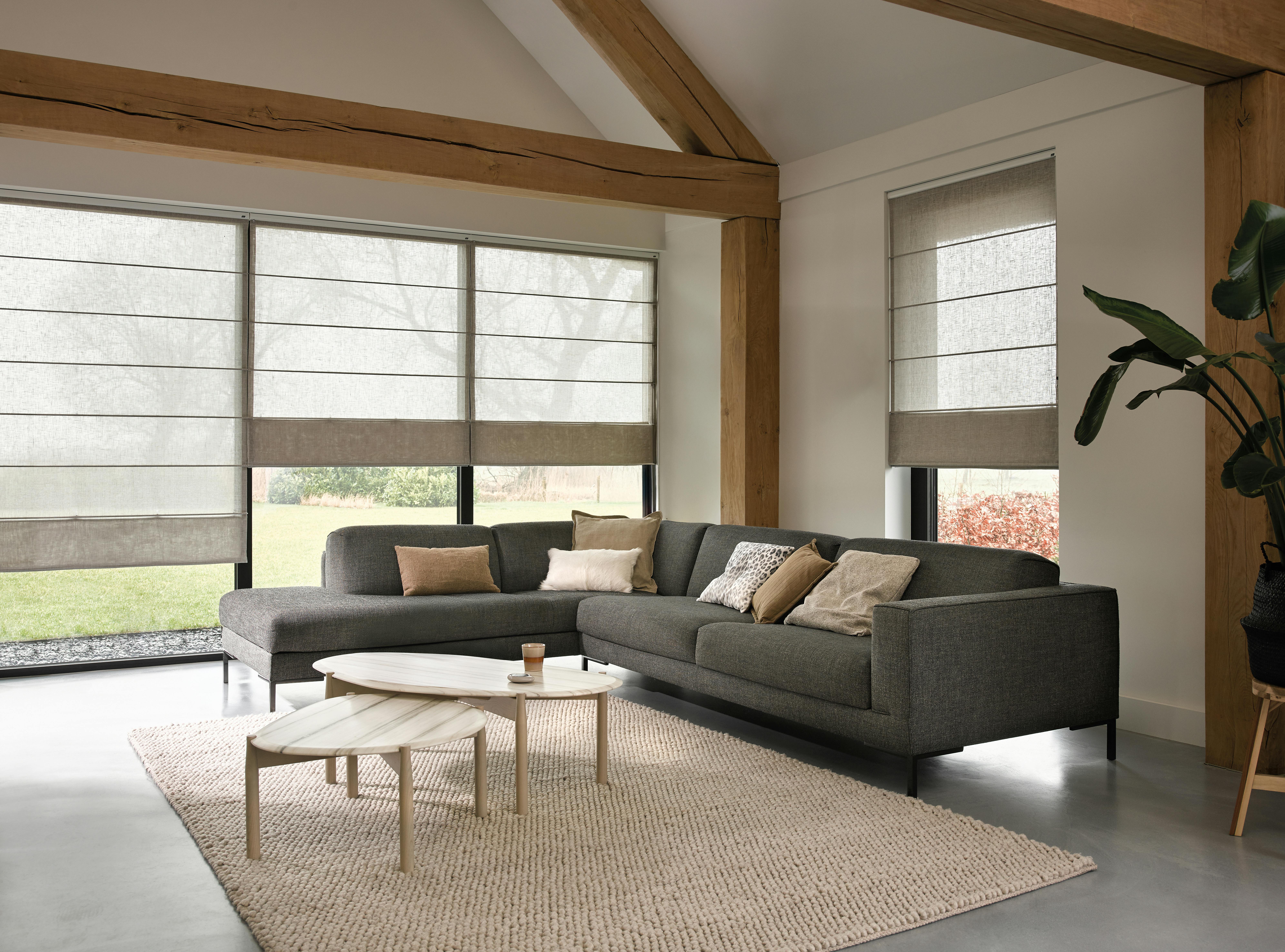 Stores textiles beiges sur une grande fenêtre dans un salon cosy