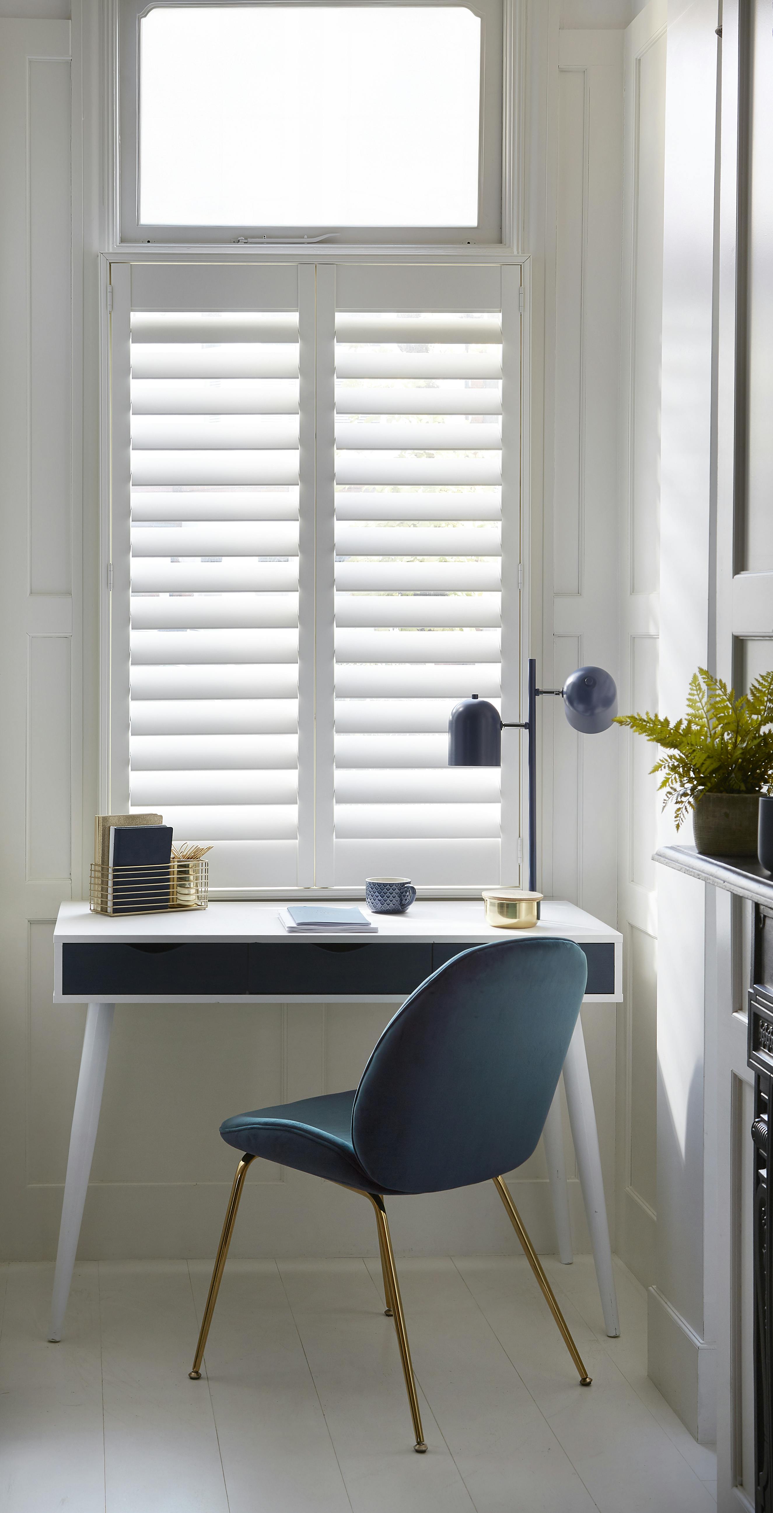 White slightly opened shutters on window in a home study room